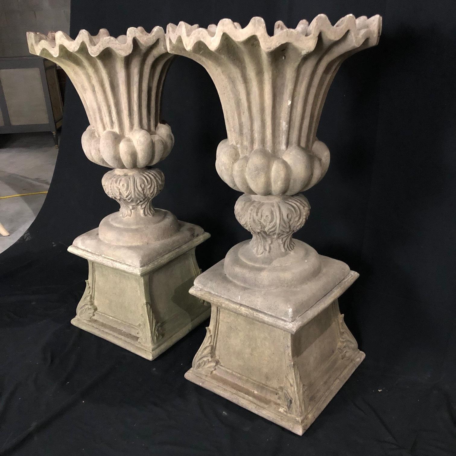 Lovely large pair of vintage French style natural resin classical design garden planters in urn shapes. Lovely aged patina! Bases separate from urns.
height of urn itself with no base 30.5”; height of base only is 13.75” 
base is 17.75”