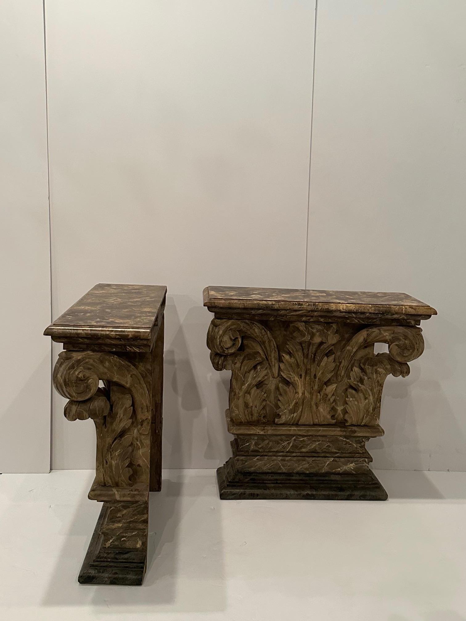 Una straordinaria e rara coppia di consolle in legno intagliato a mano dall'aspetto architettonico con foglie e colonne d'acanto e una finitura dipinta a finto marmo.
