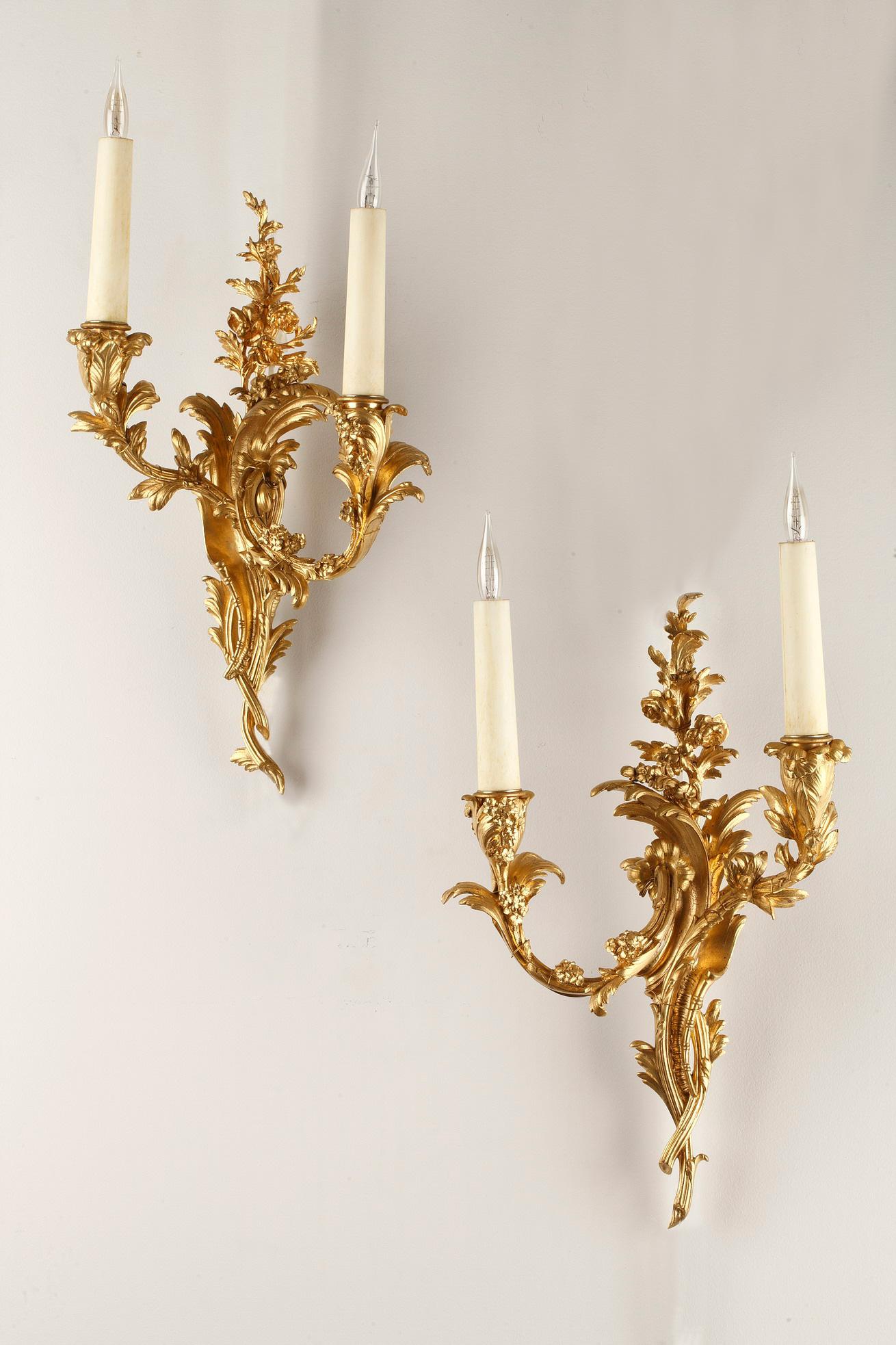 A charming pair of gilt bronze wall-lights attributed to Maison Millet, with two light-arms with leaves and flowers, issuing from a central barrel of foliage and stem and finishing in a delicate floral grouping.

The firm of Millet T. was founded in