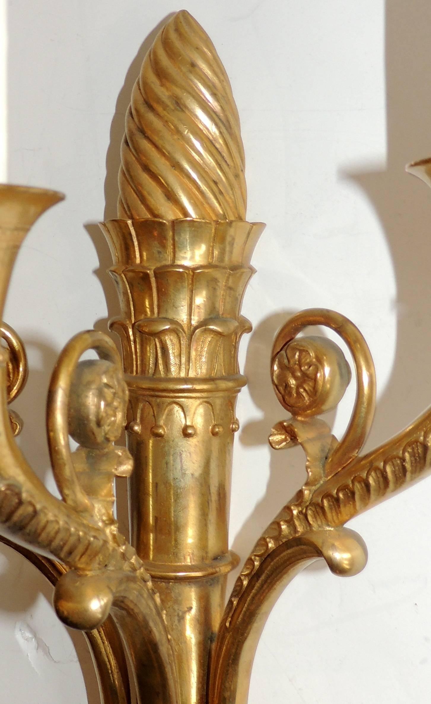 An elegant pair of Regency / neoclassical French Empire, gilt doré bronze sconces with lion heads and topped off with a twisted crown finial.

Measure: 18.5 H x 10