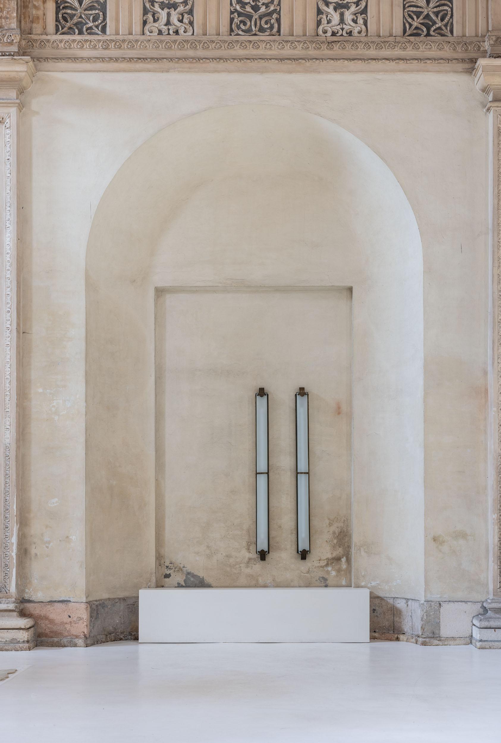 Elegante par de grandes apliques Art Decó, con cristal blanco opalino y estructura de latón con intrincados detalles decorativos, que añaden un toque de elegancia atemporal a cualquier espacio. 
Estas impresionantes lámparas, con sus llamativas