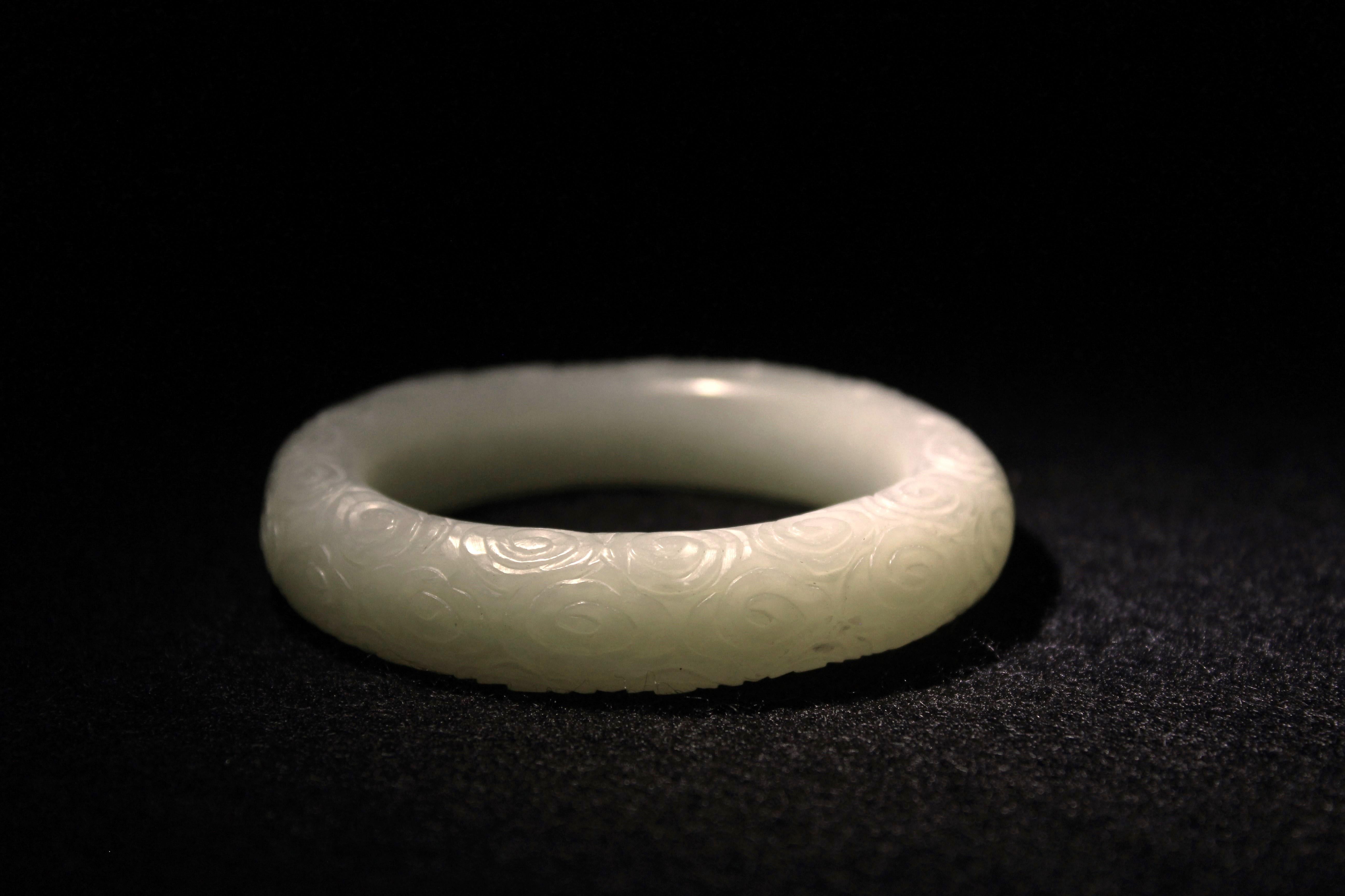 Magnifique bracelet en jade blanc céladon pâle sculpté à la main, présentant un motif de nuage rappelant les motifs décoratifs en vogue pendant la période Qianlong de la dynastie du milieu des Whiting. L'intérieur lisse assure un port confortable,
