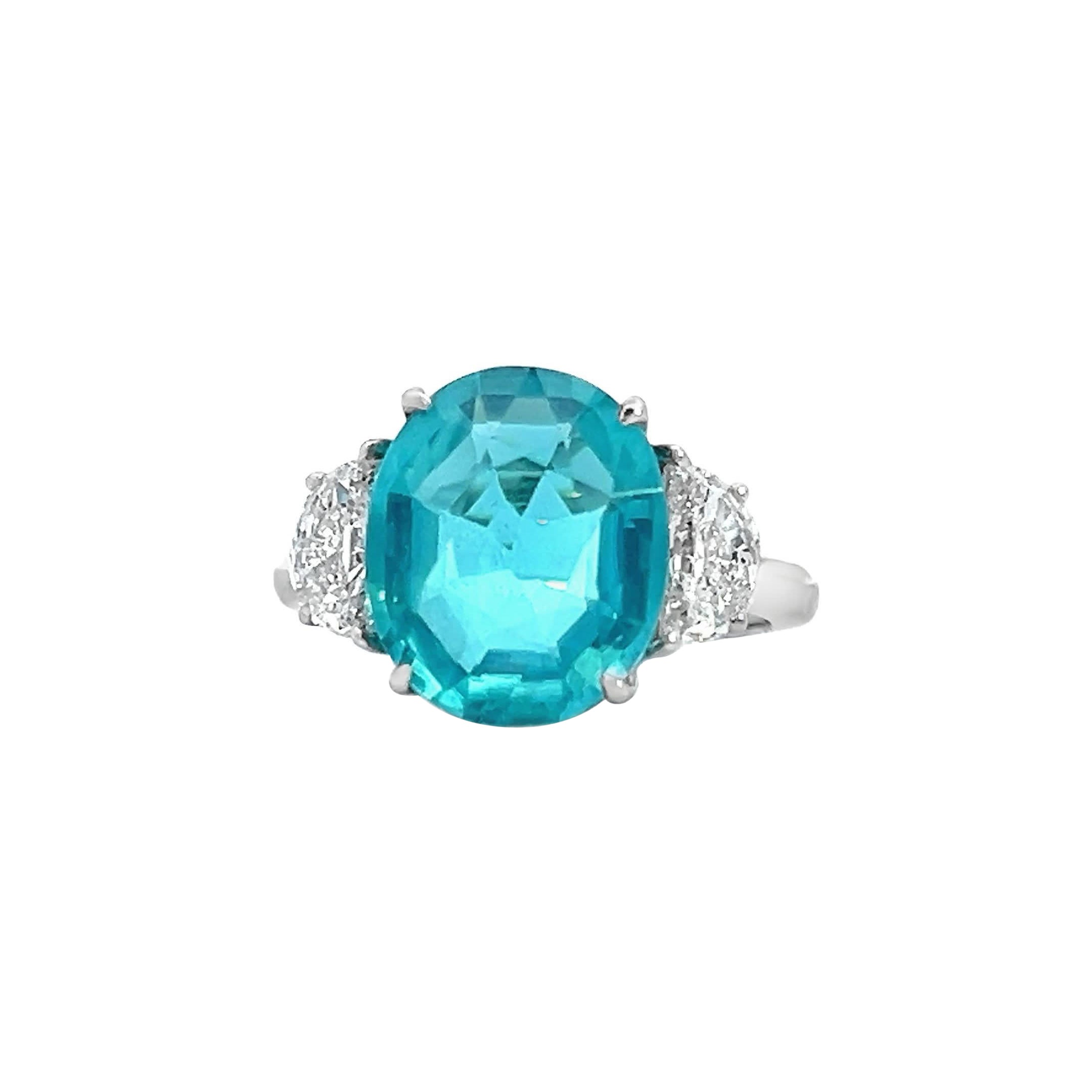 Cette bague exquise est ornée d'une pierre précieuse Paraiba, flanquée de diamants étincelants. La teinte bleue rayonnante de la pierre centrale est complétée par la brillance des diamants, ce qui en fait une pièce d'apparat parfaite pour toute