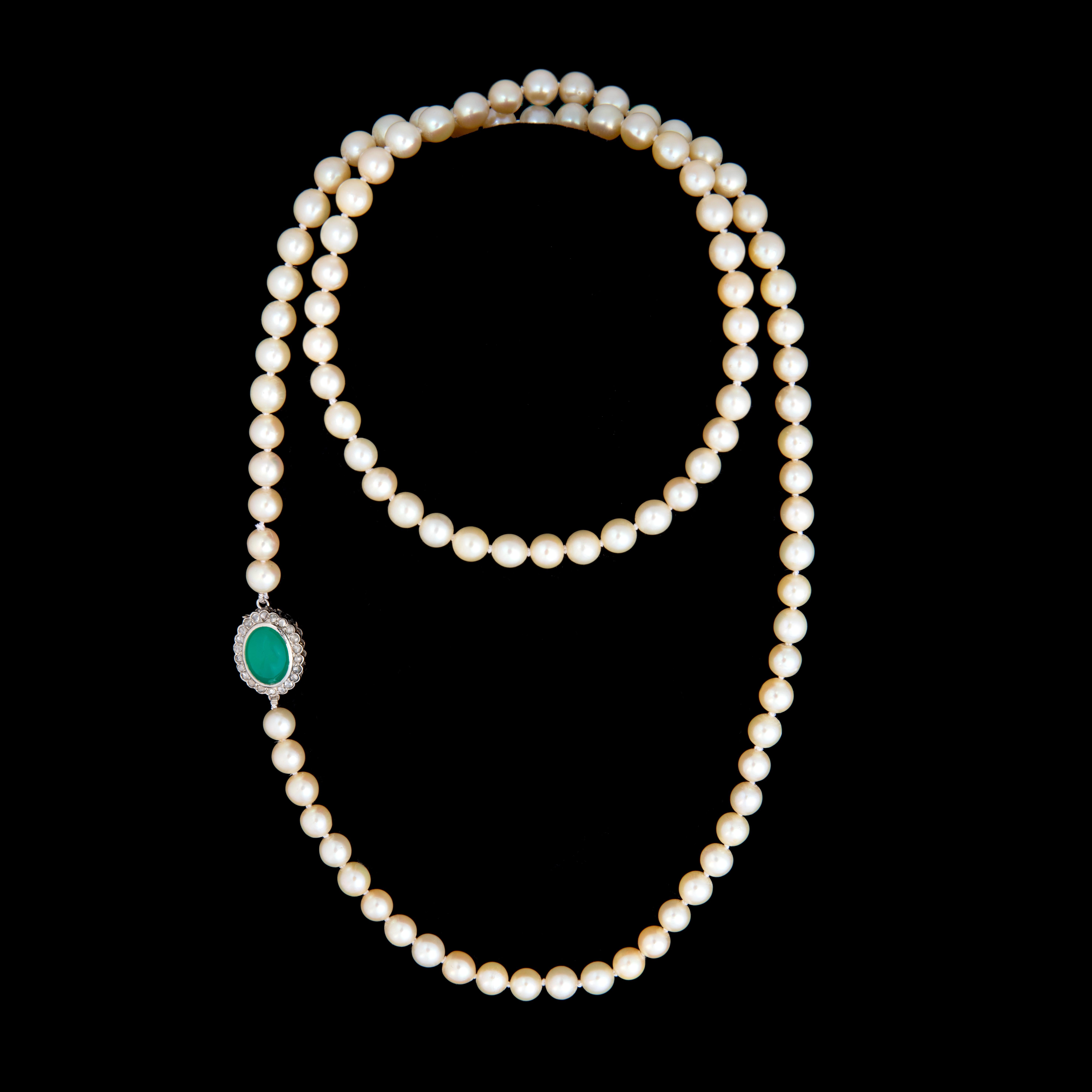 A refined strand of 88 luminous cultured pearls, elegantly graduated and hand-knotted, culminating in a striking clasp that elevates this necklace from classic to collectible. Crafted in 800/1000 yellow gold, the clasp is set with a vibrant oval