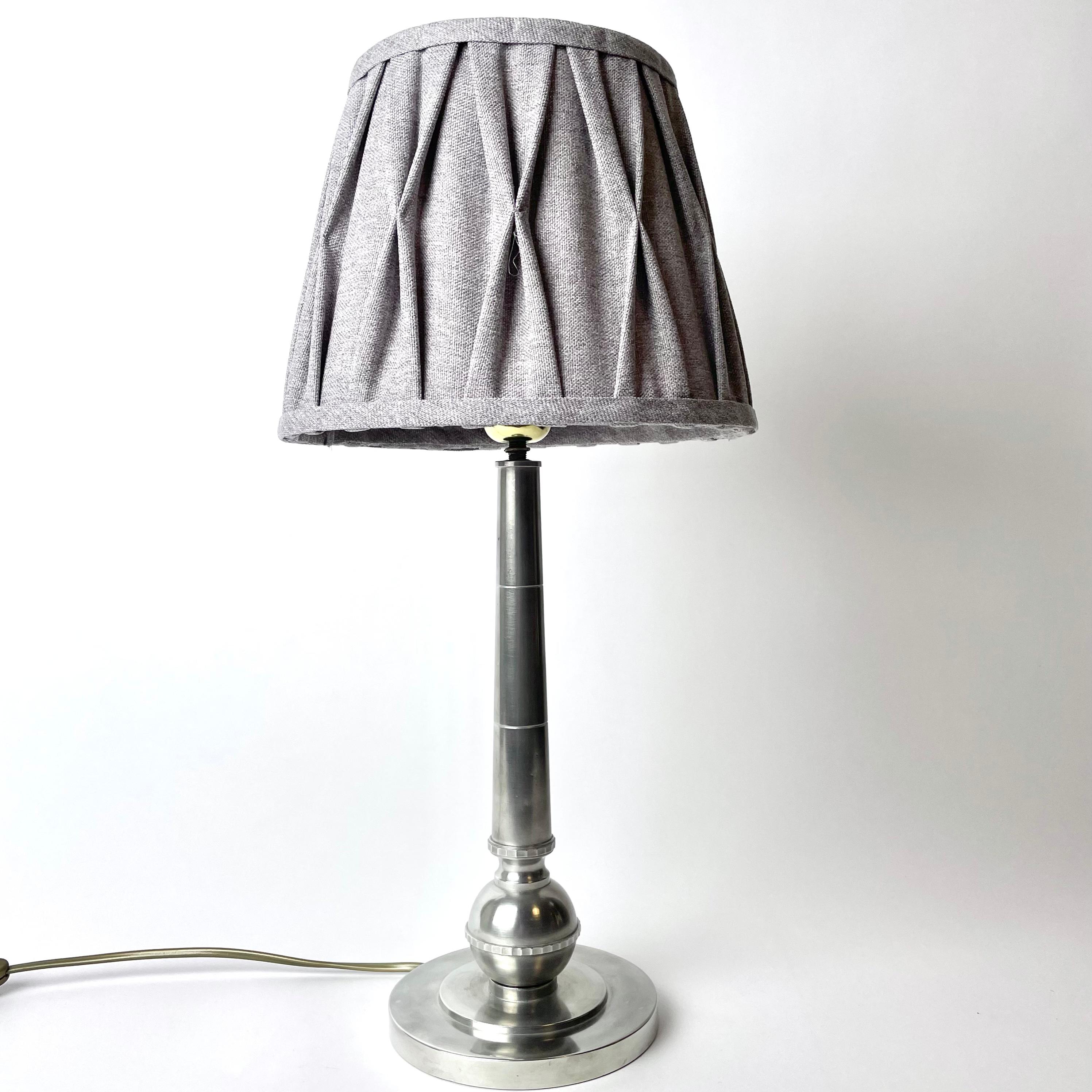 Elegante Lámpara de Peltre en Art Decó. Fabricado por el famoso fabricante C.G. Hallberg, Estocolmo, Suecia 1930 (D8 = año 1930). Artesanía fina y típica de la época del pie de estaño

Electricidad recién renovada.

Desgaste propio de la edad y el