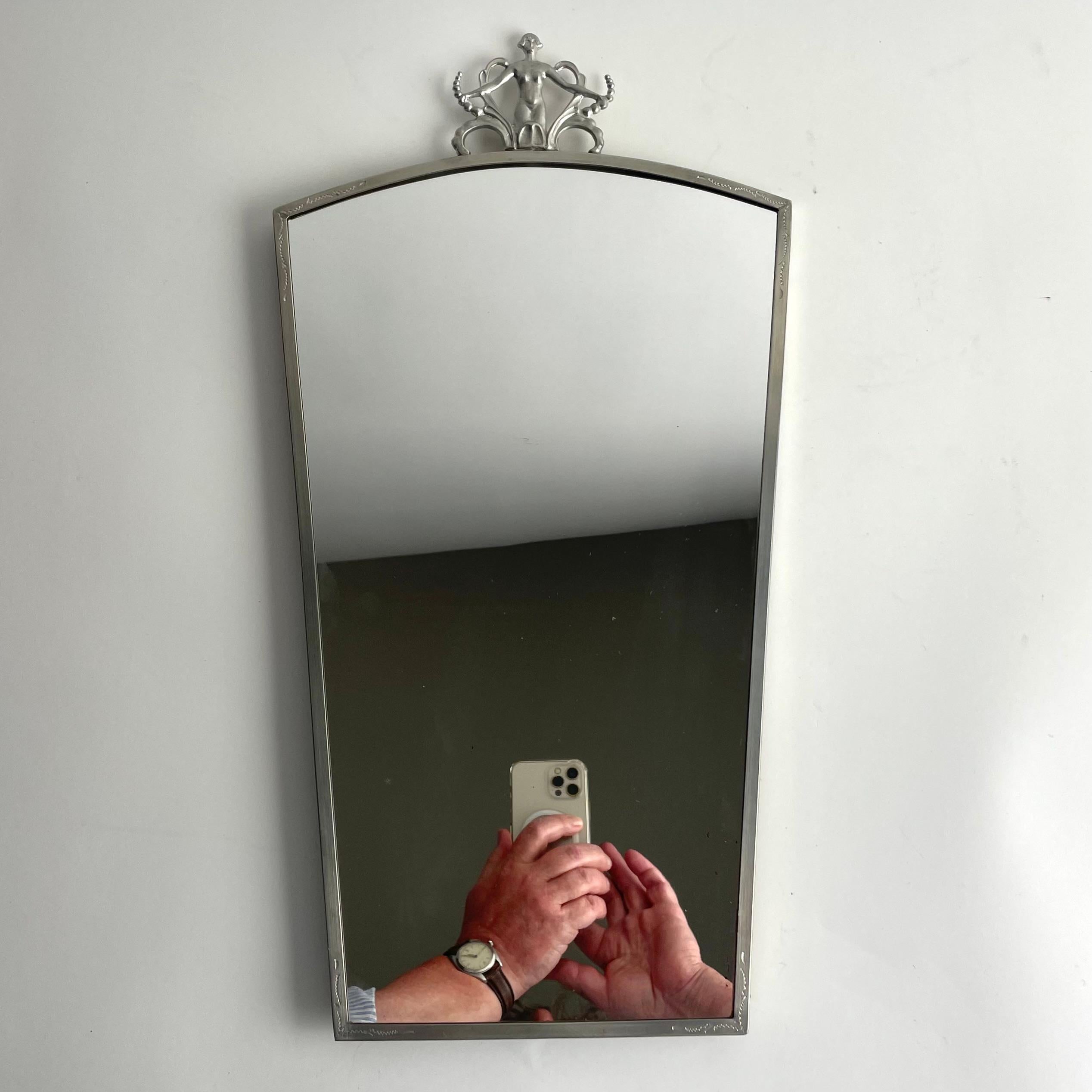 Elegant Pewter Mirror, Swedish Grace, Late 1920s

A refined and decorative mirror crafted in pewter, featuring an elegant female figure at the crest flanked by stylized florals – a hallmark of the Swedish Grace movement. Produced in Sweden during