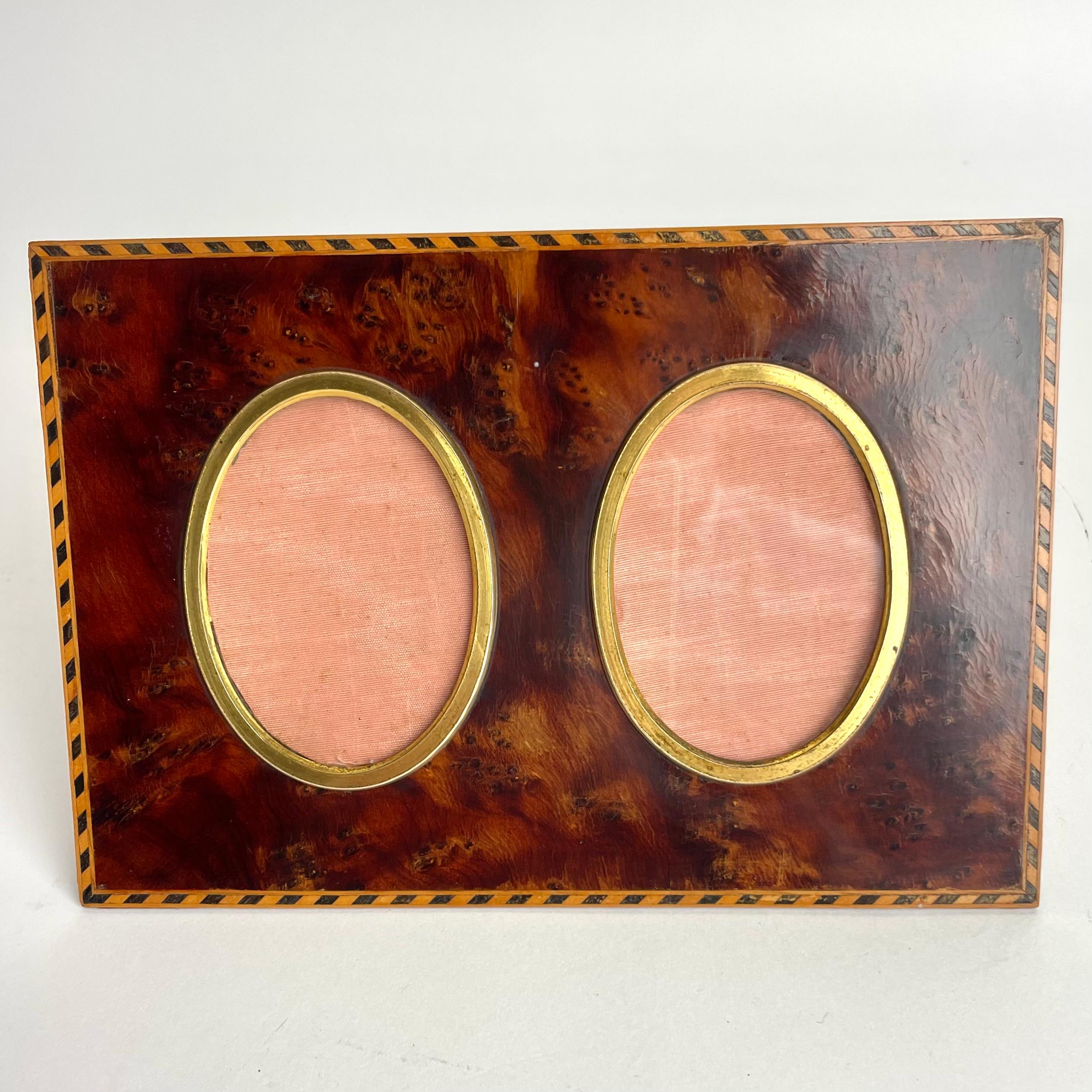 Elegant cadre photo en loupe de thuya et décor intarsia avec détails dorés des années 1930. 


Usure correspondant à l'âge et à l'usage. 