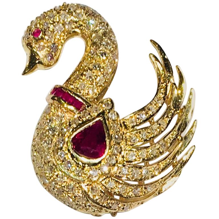Elegant and stylized estate 14 karat yellow gold swan is covered in round brilliant diamond pave and features a bezel set, pear shaped, pigeon blood red ruby, a ruby collar of invisibly set, princess cut rubies and a bezel set ruby eye.

Swan is a
