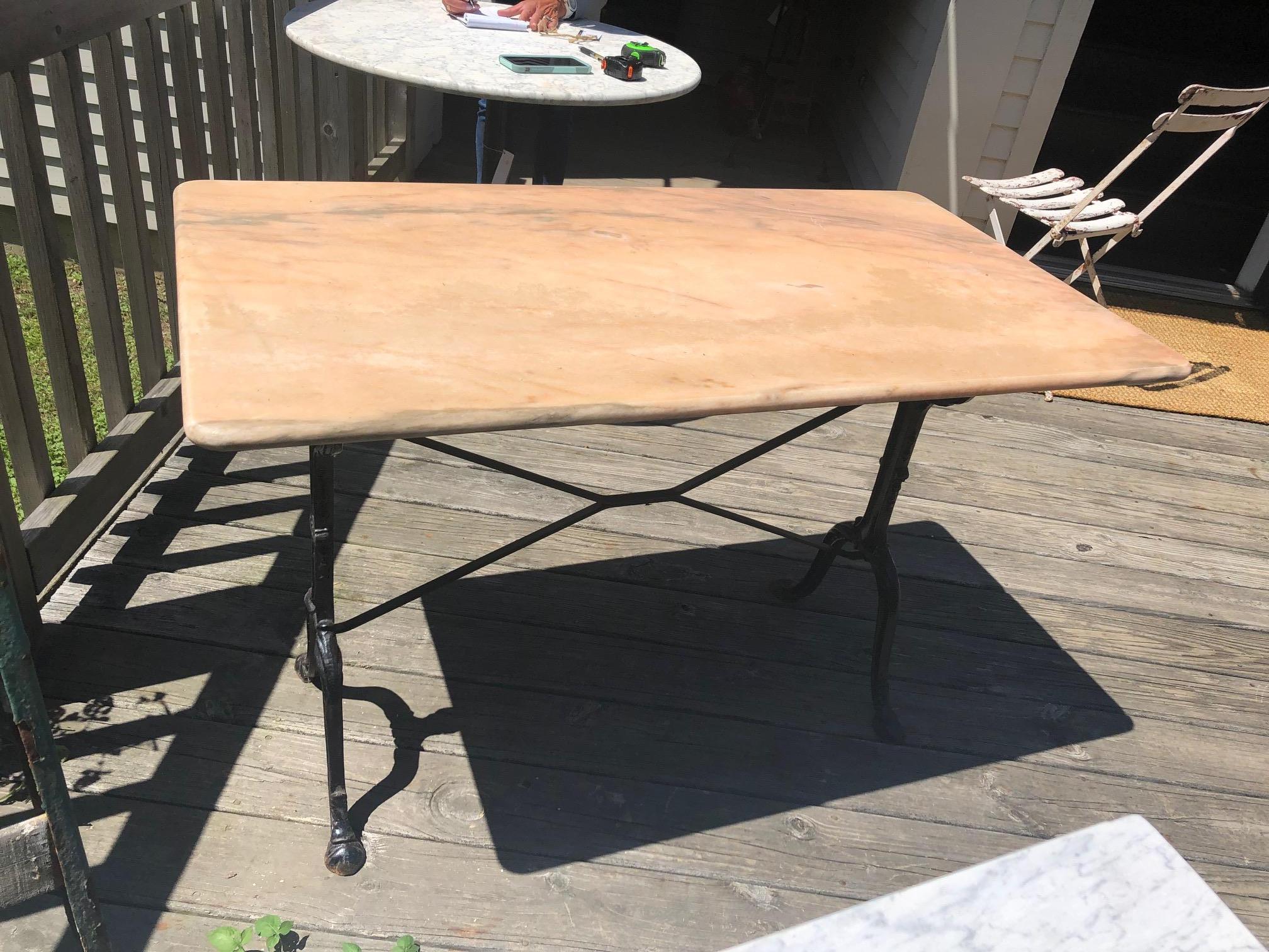 Classic French bistro table having black heavy iron base and lovely pink marble rectangular top. Perfect size as a small breakfast table or writing desk. Can be used indoors or on the patio.