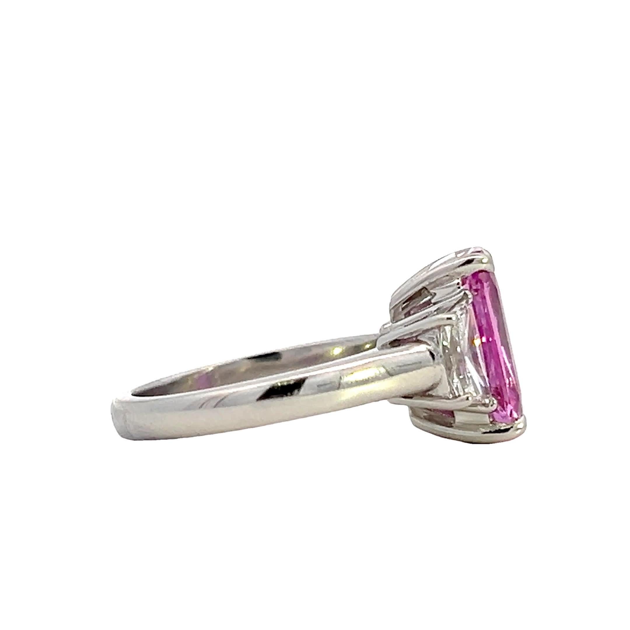 Questo squisito anello presenta uno splendido zaffiro rosa al centro, affiancato da due diamanti scintillanti ai lati. Il design elegante e il colore vivace lo rendono un pezzo forte perfetto per ogni occasione.