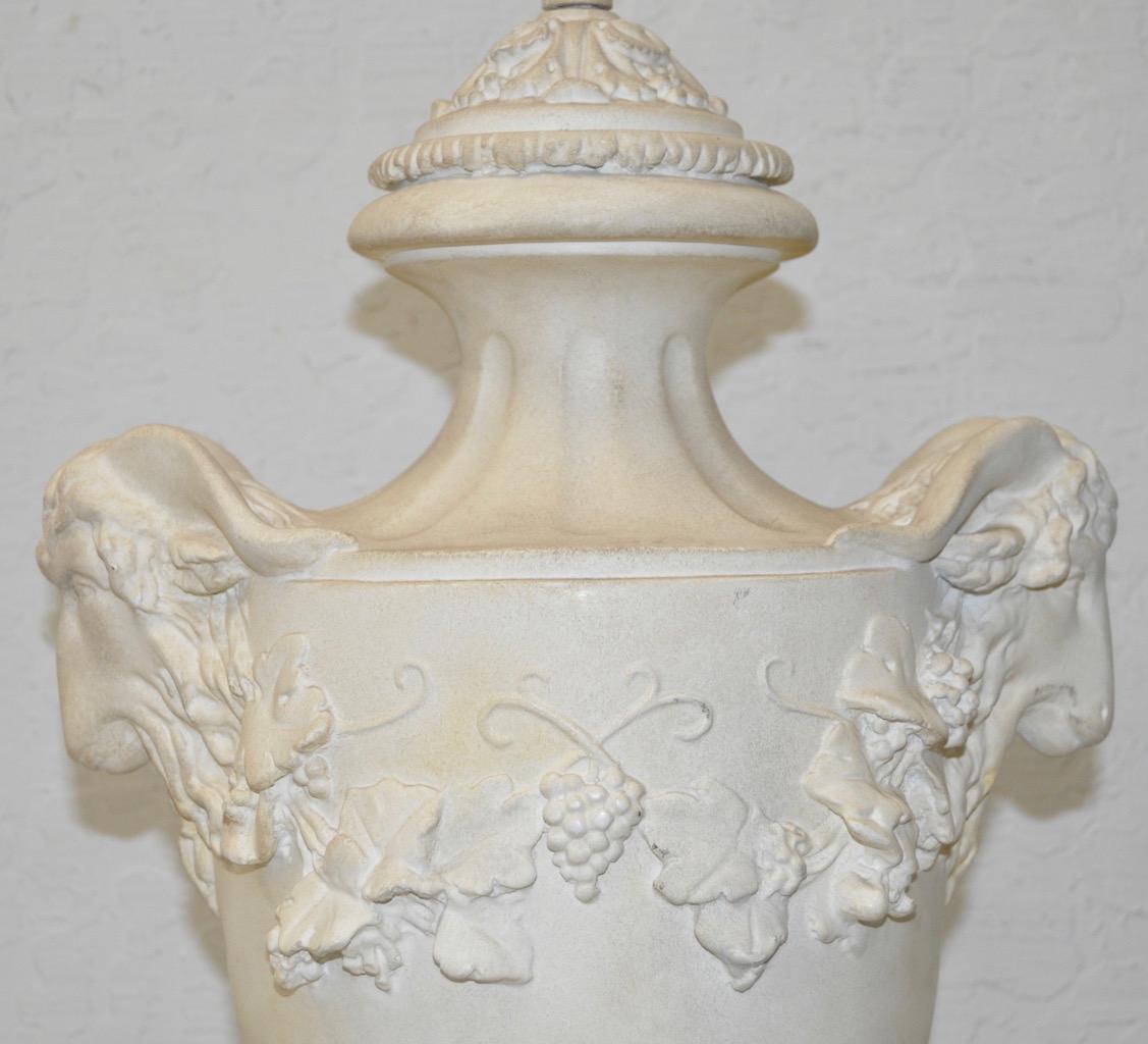 Elegant plaster urn lamp with rams head handles, circa 1950s

Beautiful urn lamp with ram headed handles and grapes.

This large plaster lamp is absolutely fabulous. The pure white of the plaster has lost some of it's shine over the years, but