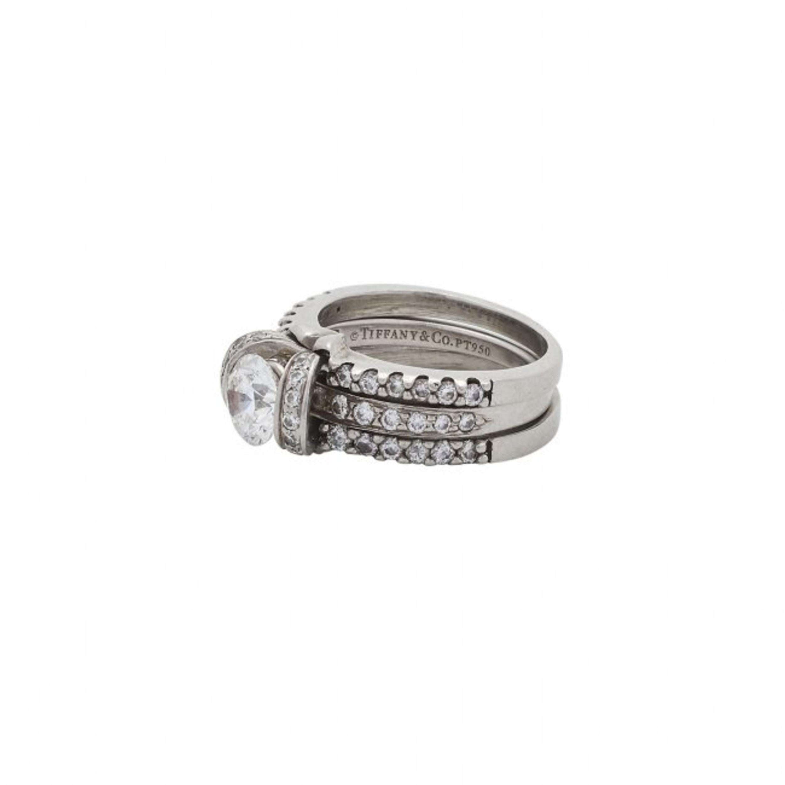 Elegant Platinum & Diamond Ring by Tiffany & Co., with diamond guards, 
The round brilliant diamond tension set round cut diamond weighing approx.
.75 carats
measuring approx. 5.8 mm by 6.02 mm, depth 3.7 mm
size 4

Catalogue note:
The Tiffany