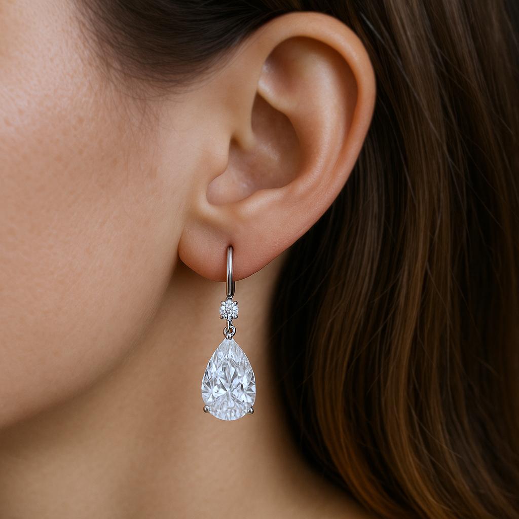 These timeless drop earrings feature a perfectly matched pair of natural pear-shaped diamonds, each weighing 0.90 carats and GIA certified. One diamond is graded F color, VS1 clarity, and the other G color, VS1 clarity—both exceptionally eye-clean