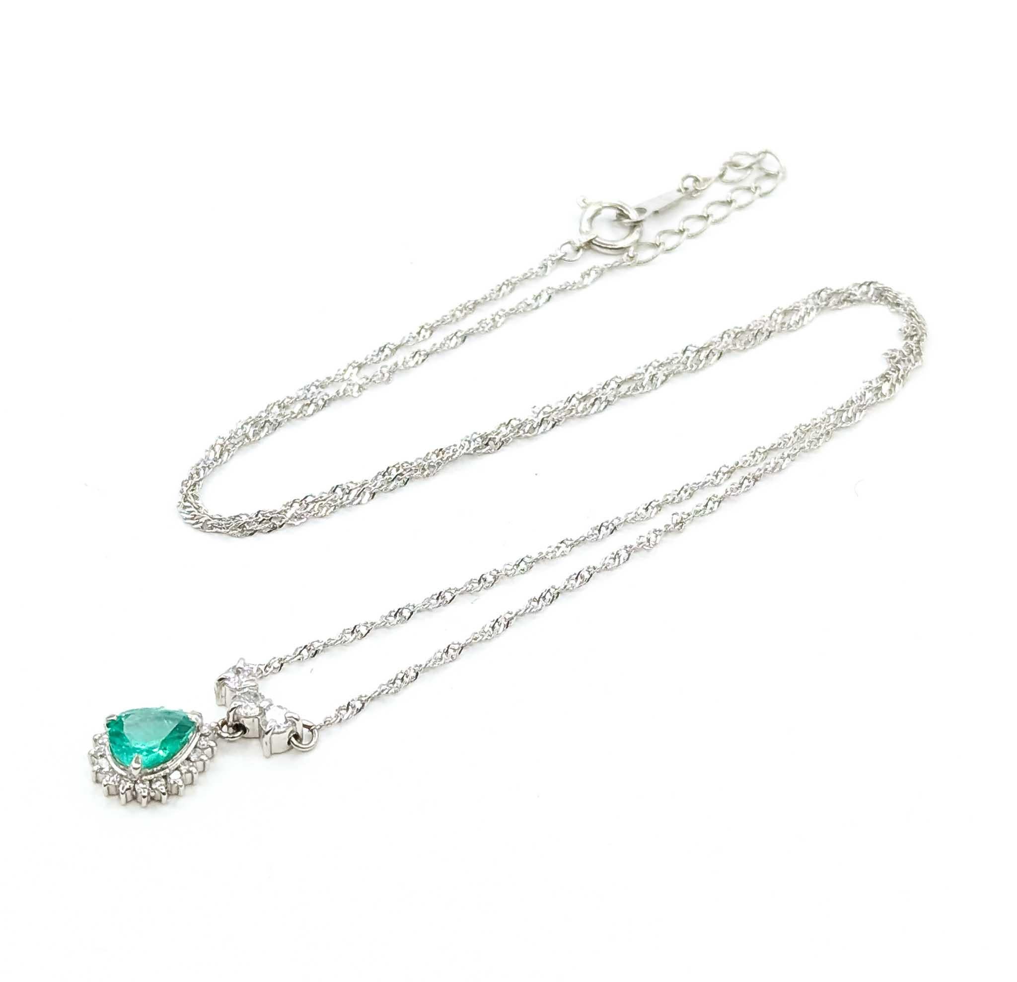 Questa elegante collana d'epoca è realizzata in platino 850 e presenta un vibrante smeraldo taglio pera del peso di 0,70 carati. Lo smeraldo è splendidamente accentuato da un'aureola e da una goccia di scintillanti diamanti rotondi per un totale di
