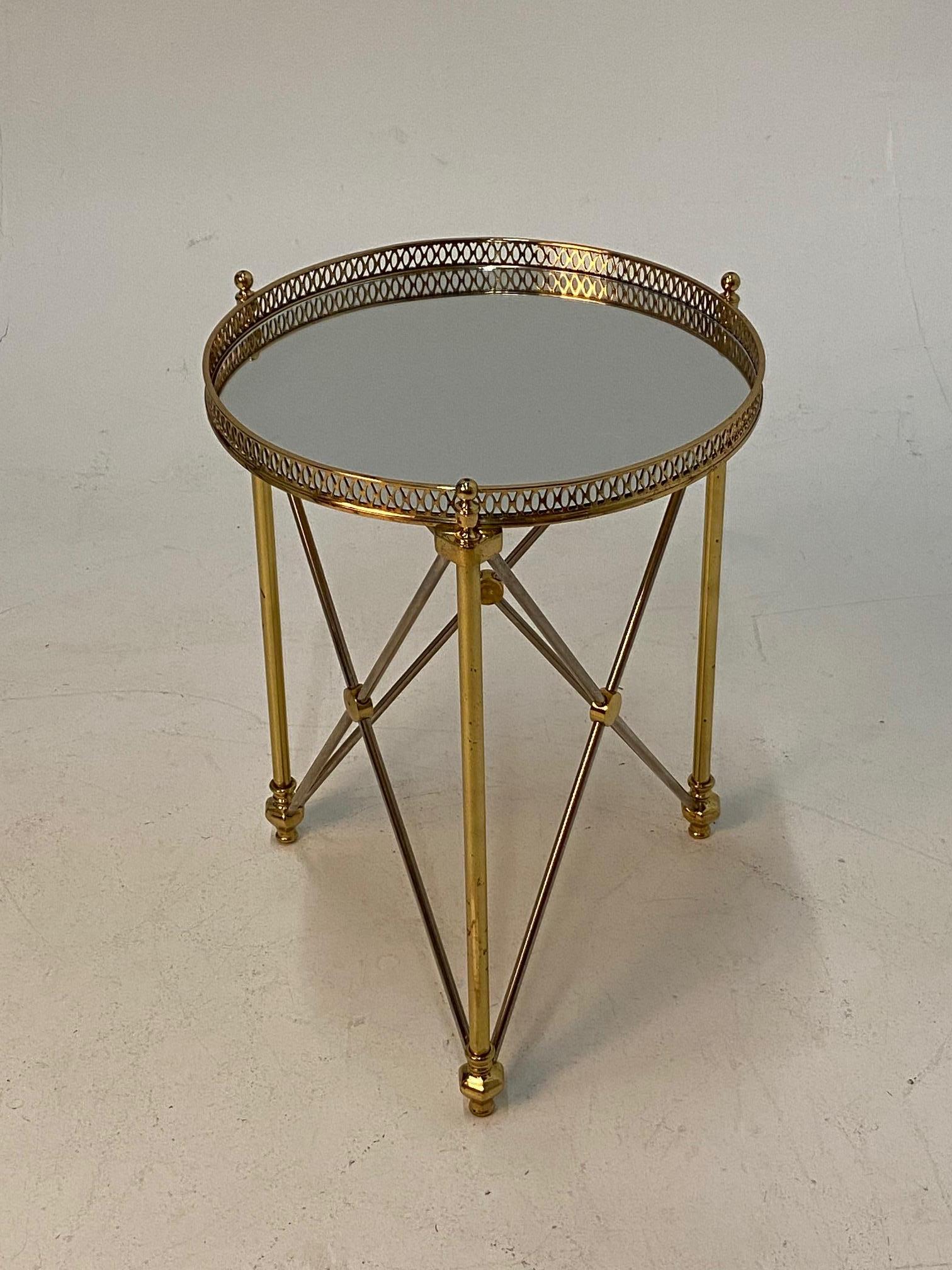 Elegant round martini table in the style of Maison Jansen having polished steel and brass neoclassical design, pierced gallery and mirrored top.
