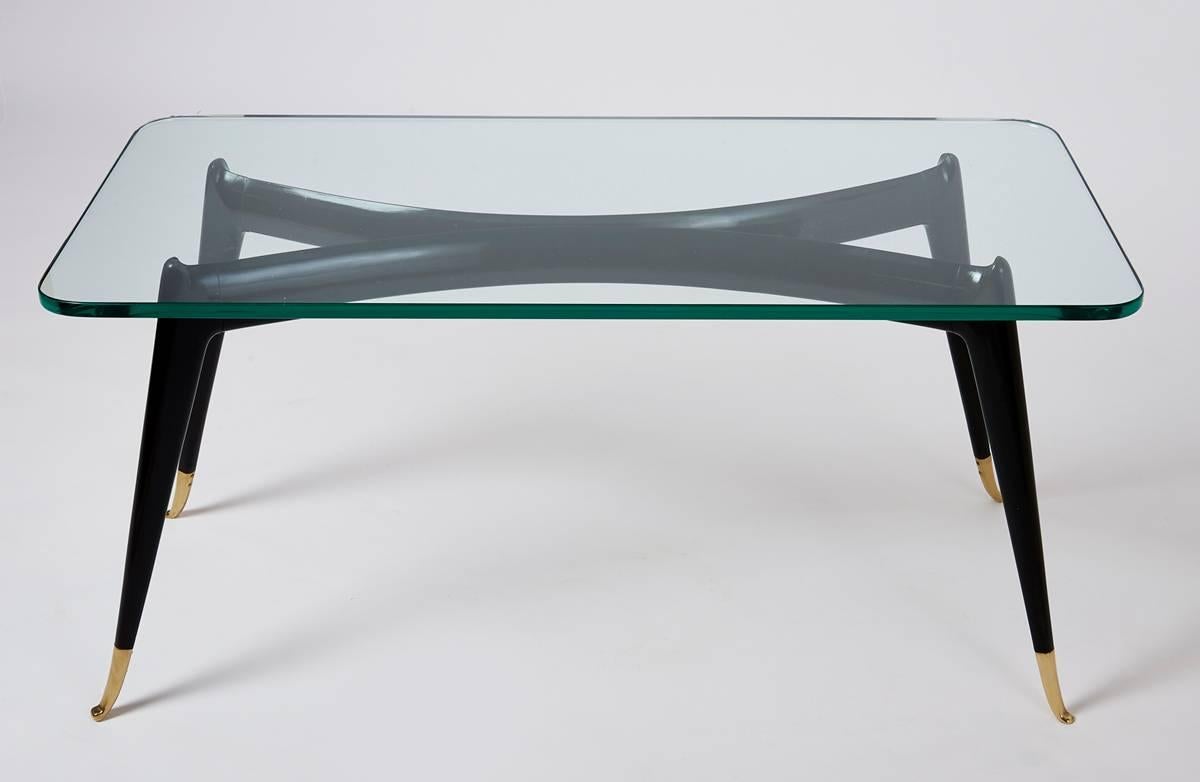 Italy, 1950s
An elegant stained wood coffee table
the gracefully carved legs delicately poised on shaped brass sabots,
the clear glass top resting on modeled raised spurs at the knee joint.
Dimensions: 39.5 x 19.5 x 18 H.
