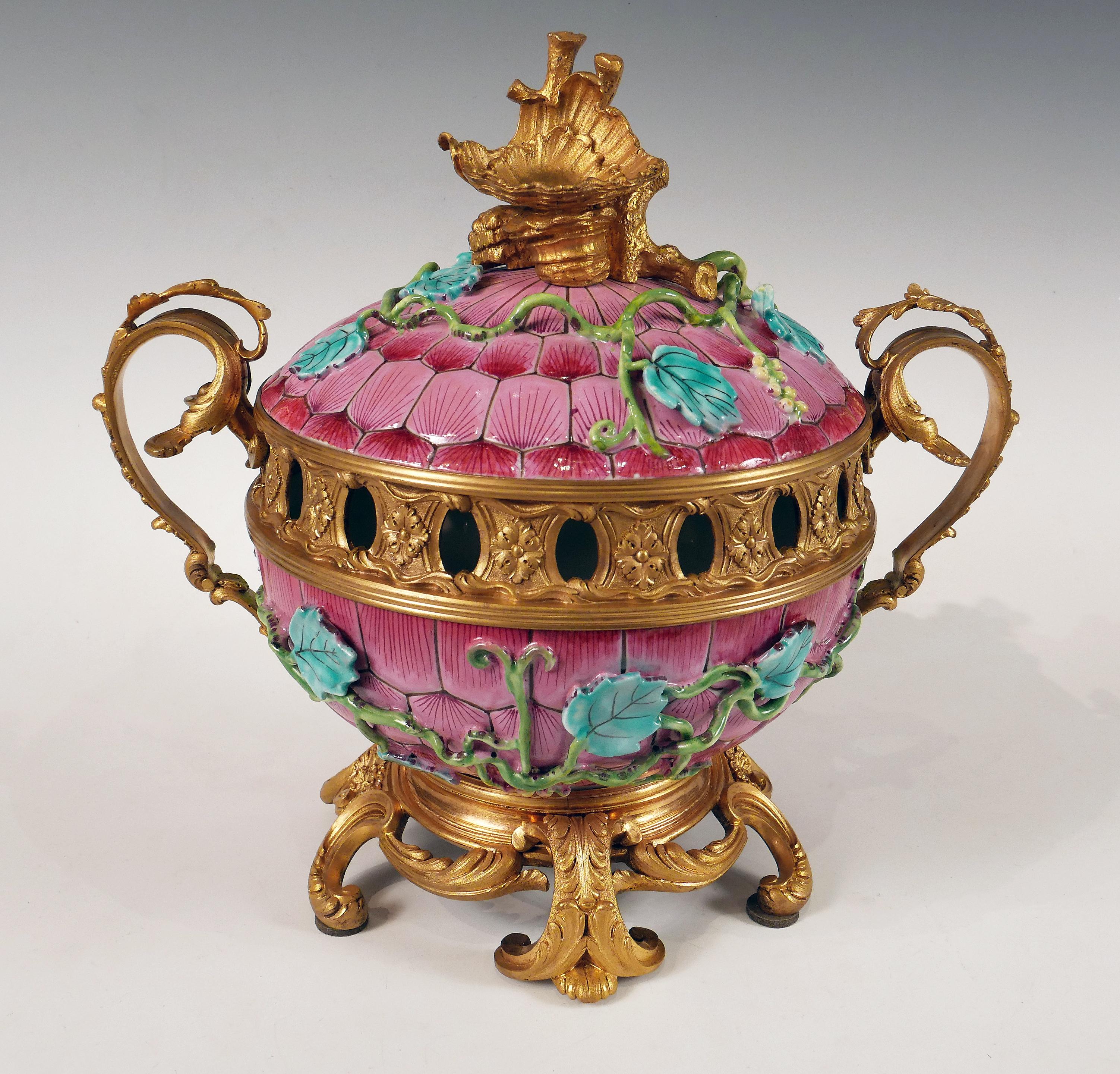 Large enamelled porcelain perfume burner decorated with vines on a background of rose petals. The set is embellished with an elegant mount in chiseled and gilded bronze formed by an openwork gallery on the collar, windings and foliage forming the