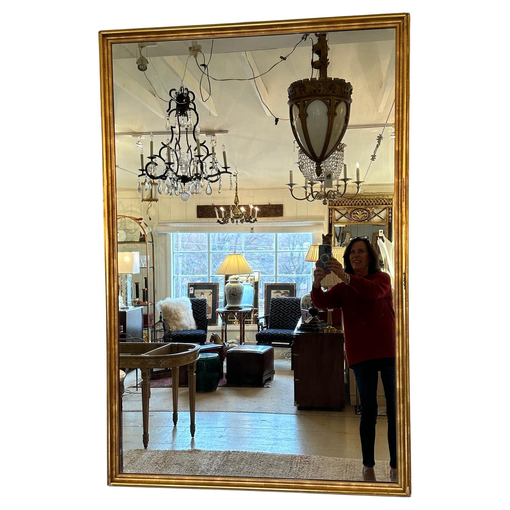 Large elegant rectangular antique lemon gilt wall mirror from the 19th century.
