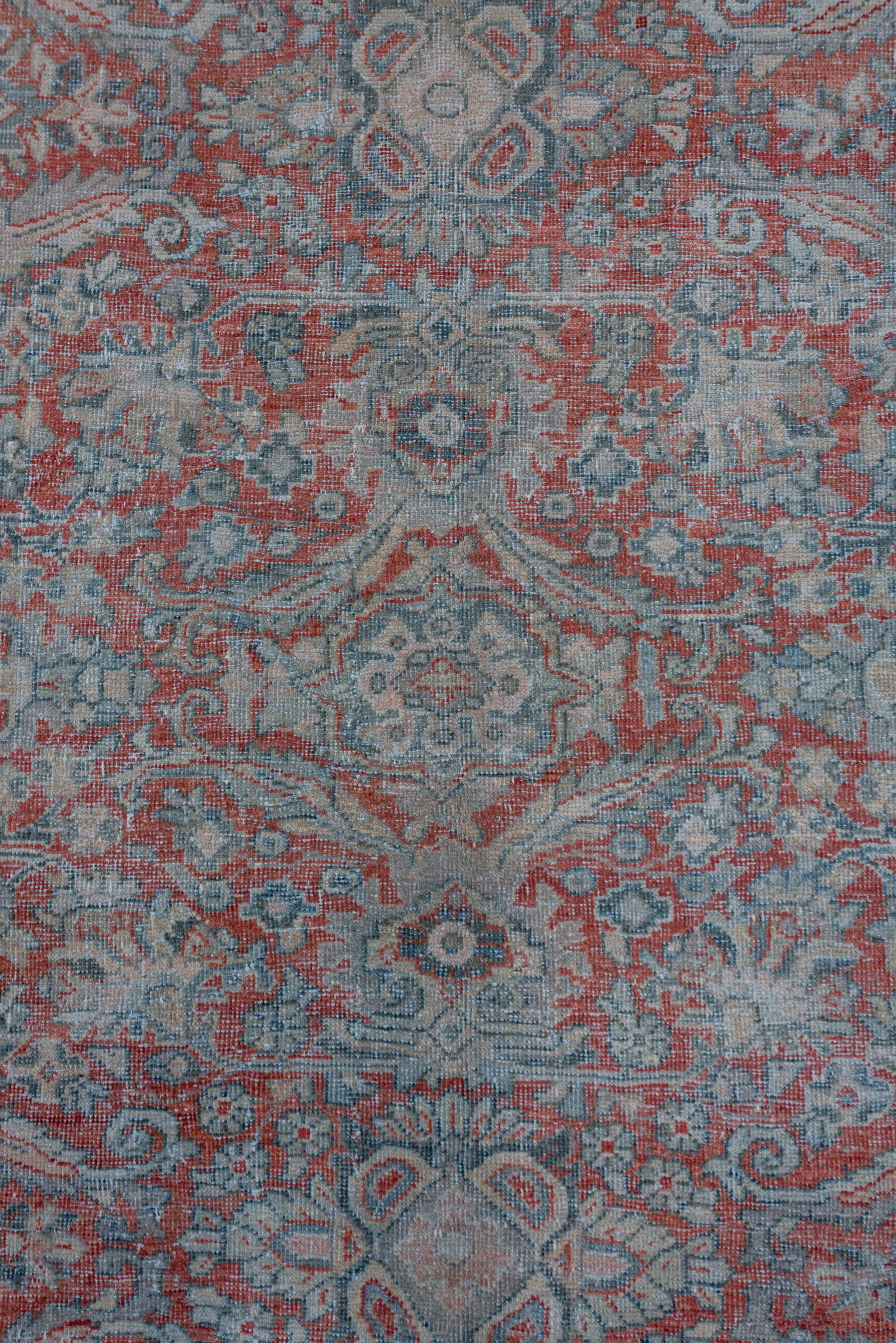 The madder red field displays an all-over design in a general Herati style, but with longer lancet leaves forming broken lozenges, with attractive teal and ivory accents. The slate-blue border features oblique floral sprays, rosettes and palmettes.