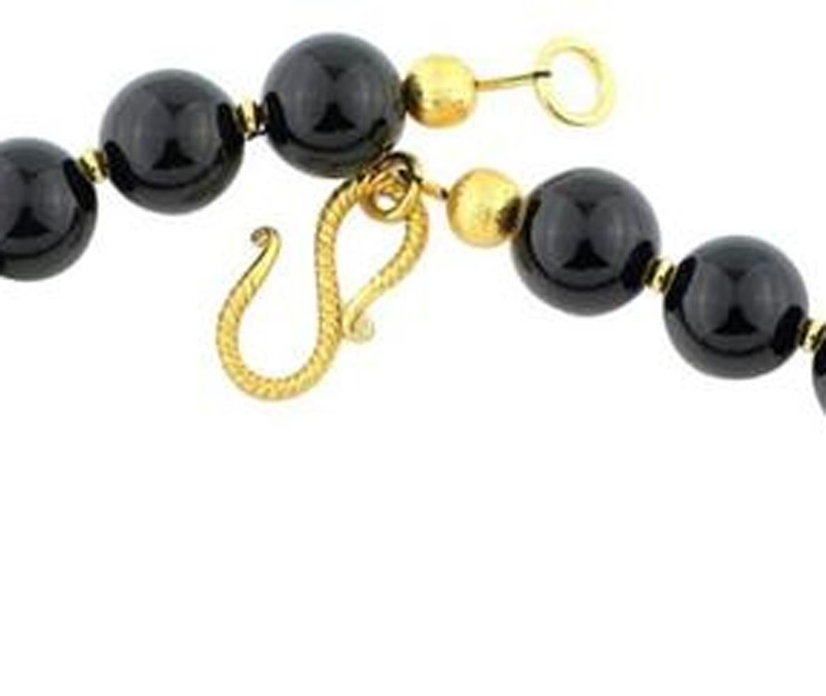 Eccezionali gemme di onice nero lucidate a specchio, impreziosite da pendenti naturali di corallo rosso di bambù con accenti placcati in oro su questa collana fatta a mano.  Dimensioni:  Corallo più lungo 41 mm
Lunghezza:  16,5 pollici;  Chiusura: 