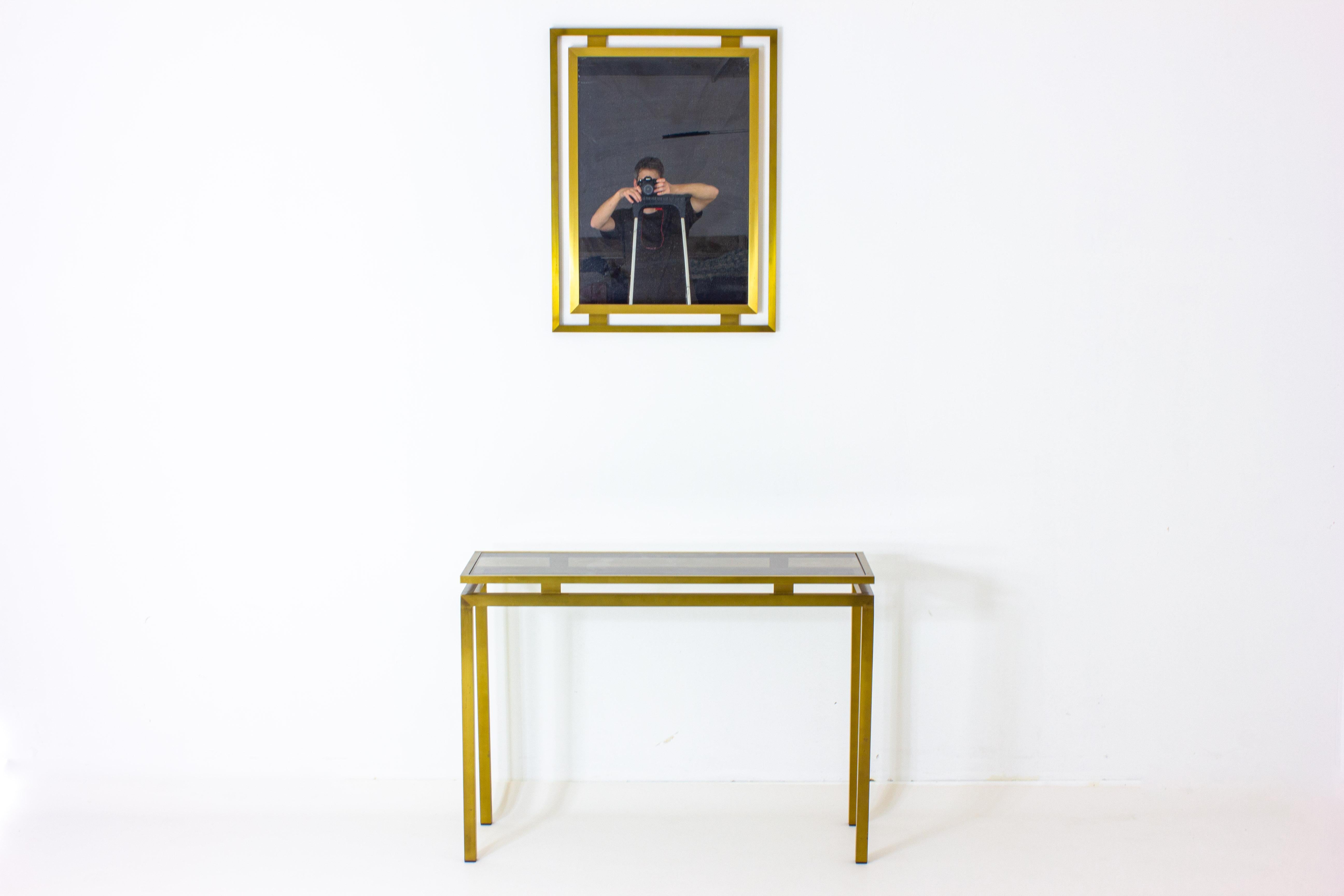 Introduce the glamorous era of the 1980s with our exquisite Hollywood Regency Brass Wall Console and Mirror set. The console, with its sleek lines and lustrous brass finish, exudes an air of sophistication that instantly elevates any space. Its