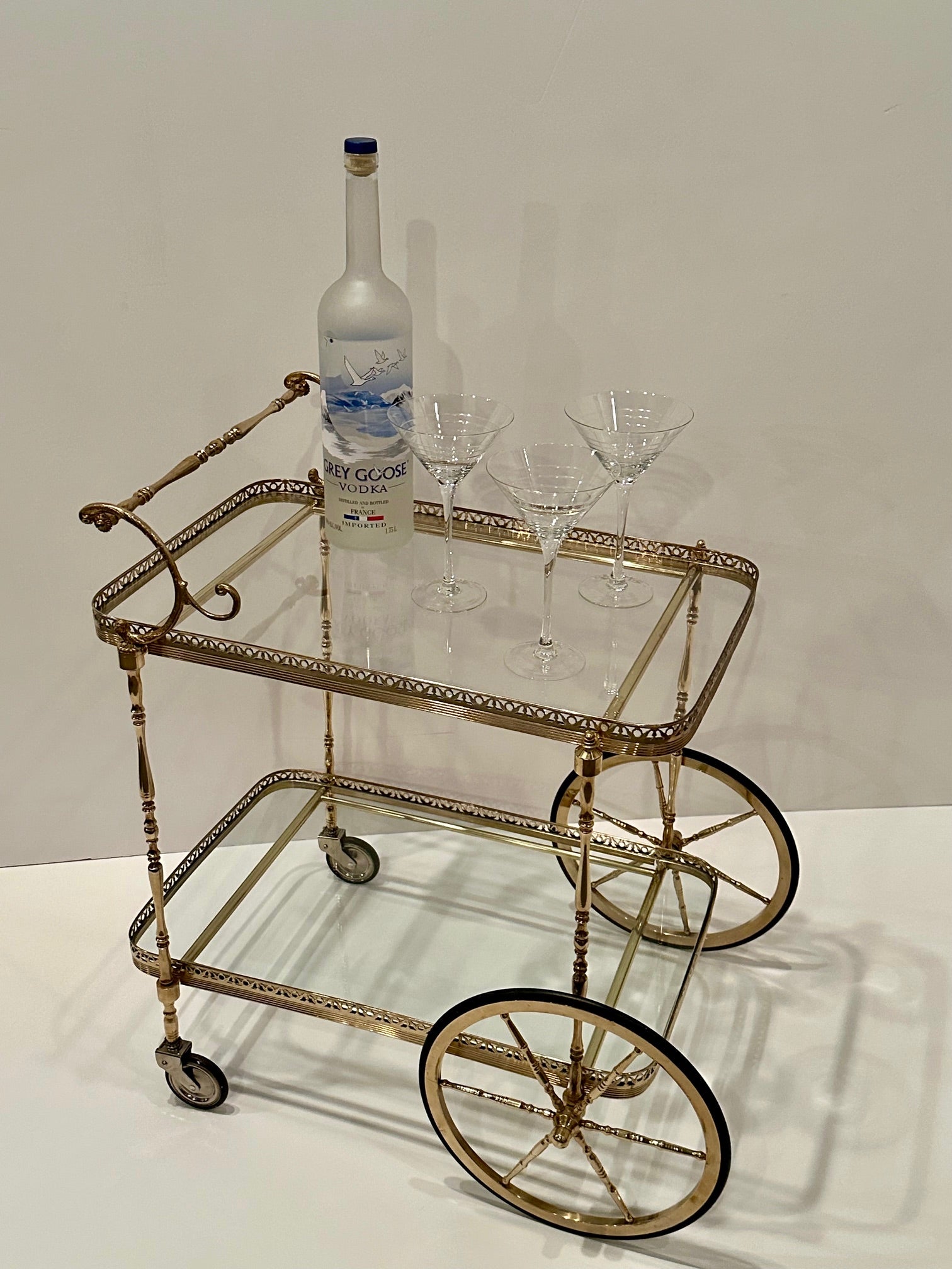 Elegant Rococo French cast brass and glass two tier bar cart having 2 removable tray surfaces and lovely galleries around the trays.
29.5 h to top of handle