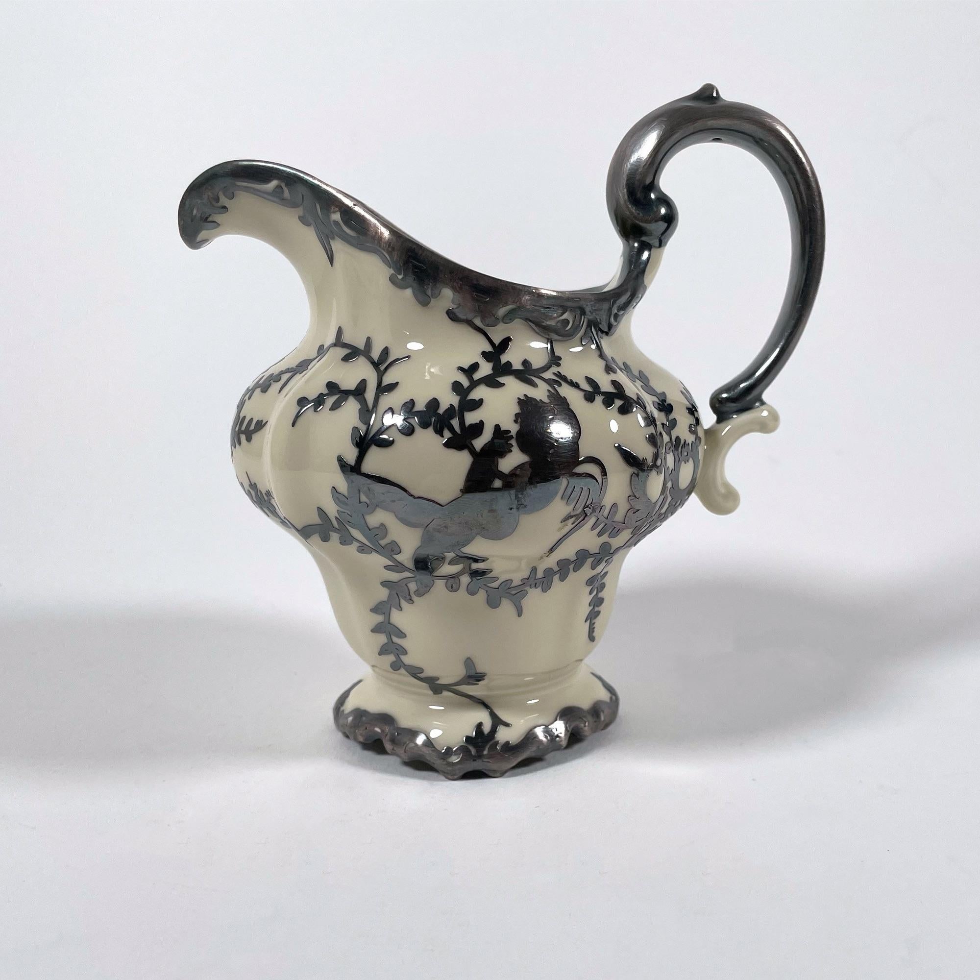 Cet exquis ensemble pot à lait et sucrier Rosenthal Pompadour est un exemple intemporel de la finesse de la porcelaine allemande des années 1940. Doté du modèle emblématique Pompadour, cet ensemble est orné d'une délicate finition en poudre argentée