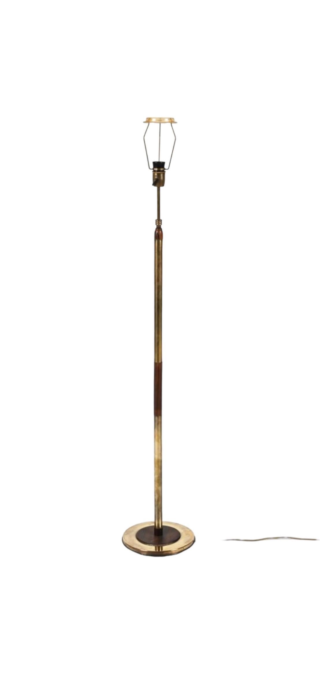 Elegant and unique mid century modern floor lamp. Executed in brass and Brazilian rosewood, in a rare combination of classic materials from the era. Originally of European origin. The height of the lamp is adjustable, hidden by a creative internal