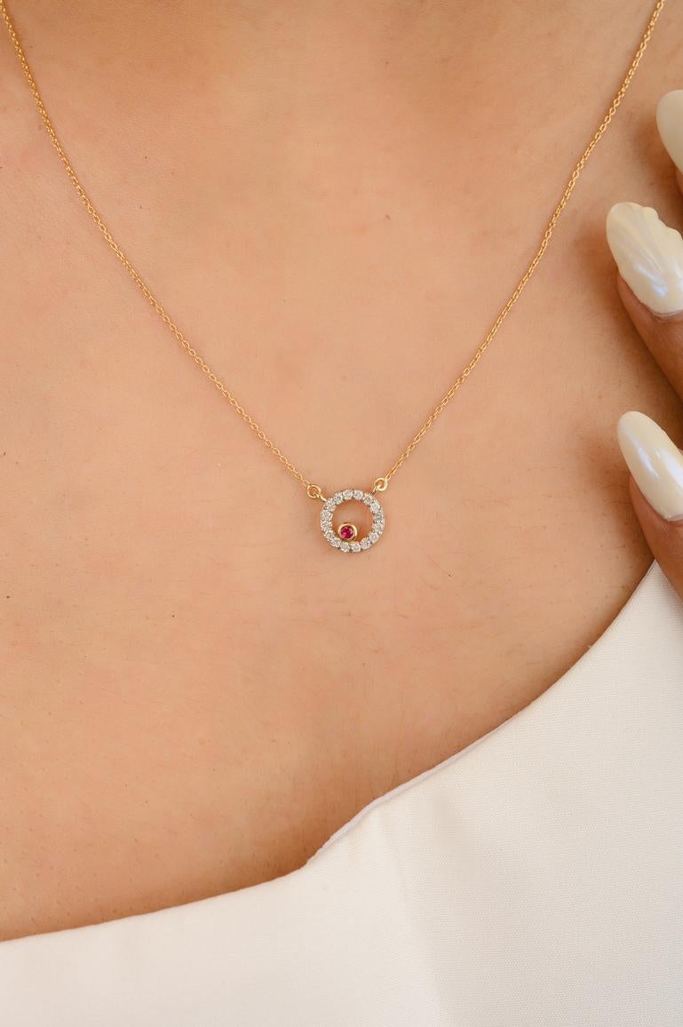 Ruby and Diamond Necklace in 14K Gold studded with round cut ruby in a diamond studded circle. This stunning piece of jewelry instantly elevates a casual look or dressy outfit. 
Ruby improves mental strength. 
Designed with a diamond circle with