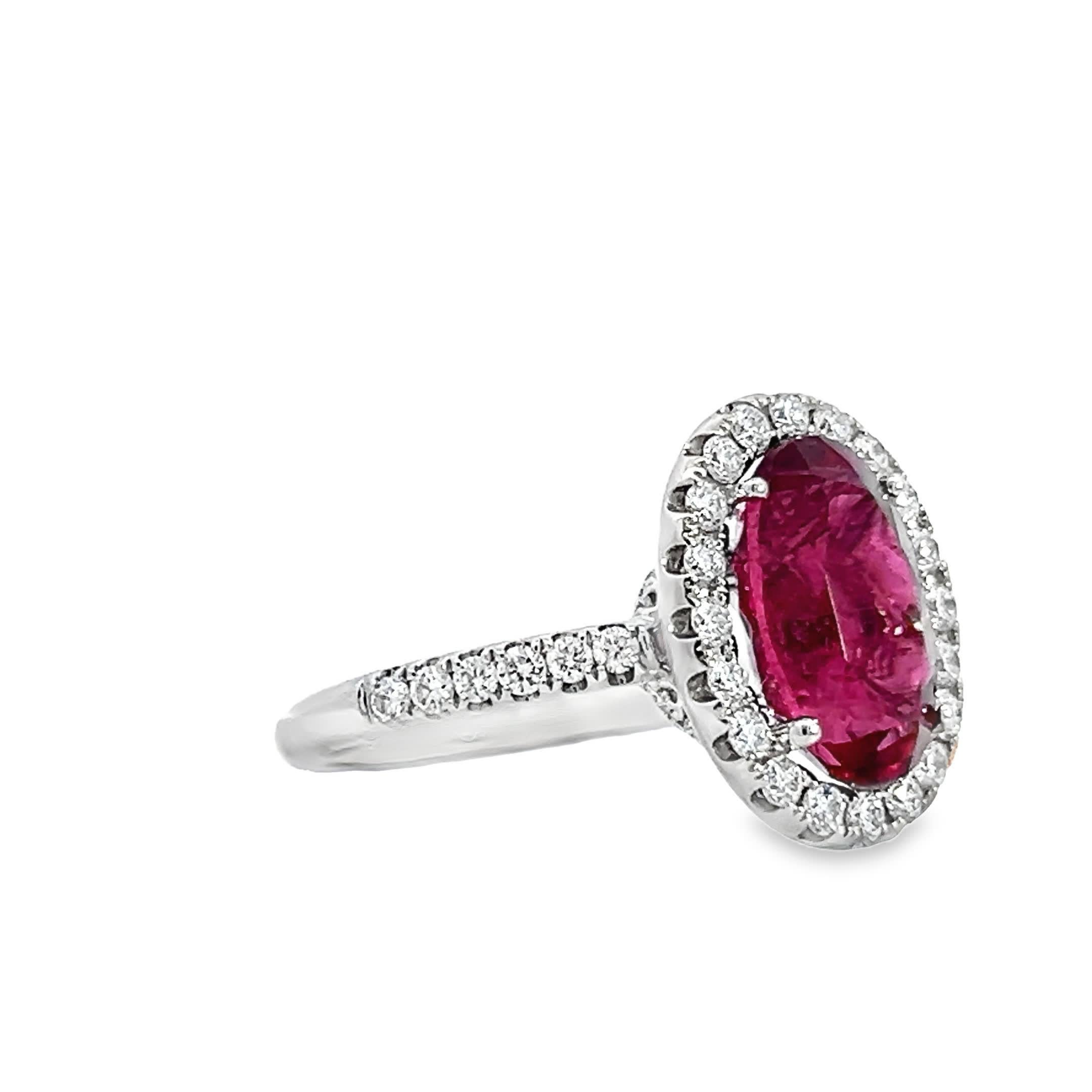 Questo squisito anello presenta uno splendido rubino di forma ovale, circondato da un'aureola di diamanti scintillanti incastonati nell'oro bianco. Perfetto per aggiungere un tocco di eleganza a qualsiasi abbigliamento.