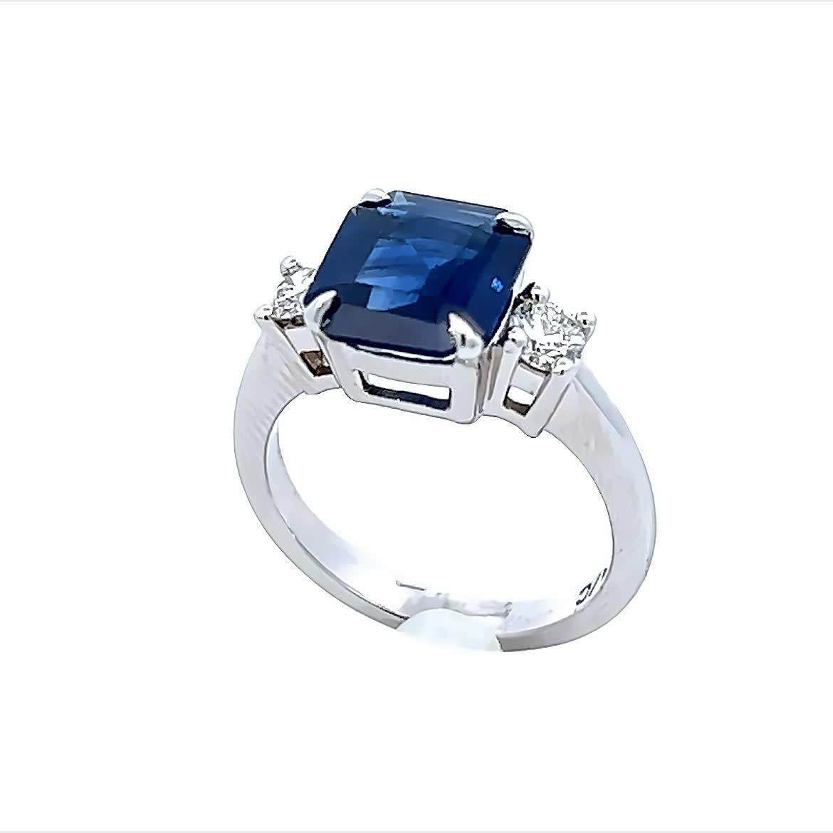 Discover the timeless beauty of this elegant sapphire and diamond ring. The stunning deep blue sapphire is complemented by sparkling diamonds on either side, creating a perfect balance of color and brilliance. This exquisite piece is ideal for