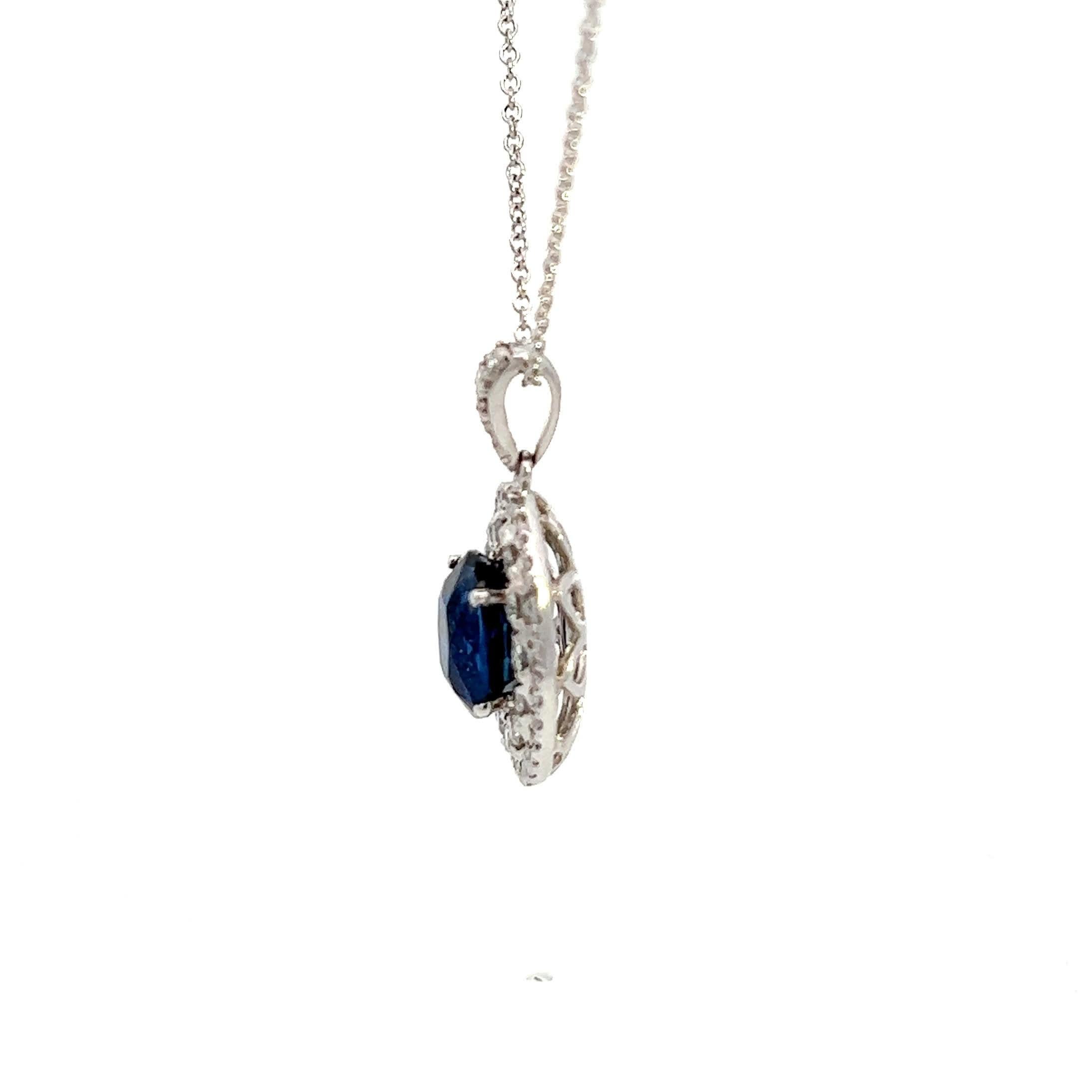 Questa splendida collana con ciondolo a forma di zaffiro presenta uno zaffiro ovale di colore blu intenso circondato da un'aureola di diamanti scintillanti. Realizzato con precisione, il ciondolo pende con grazia da una delicata catenina, rendendolo