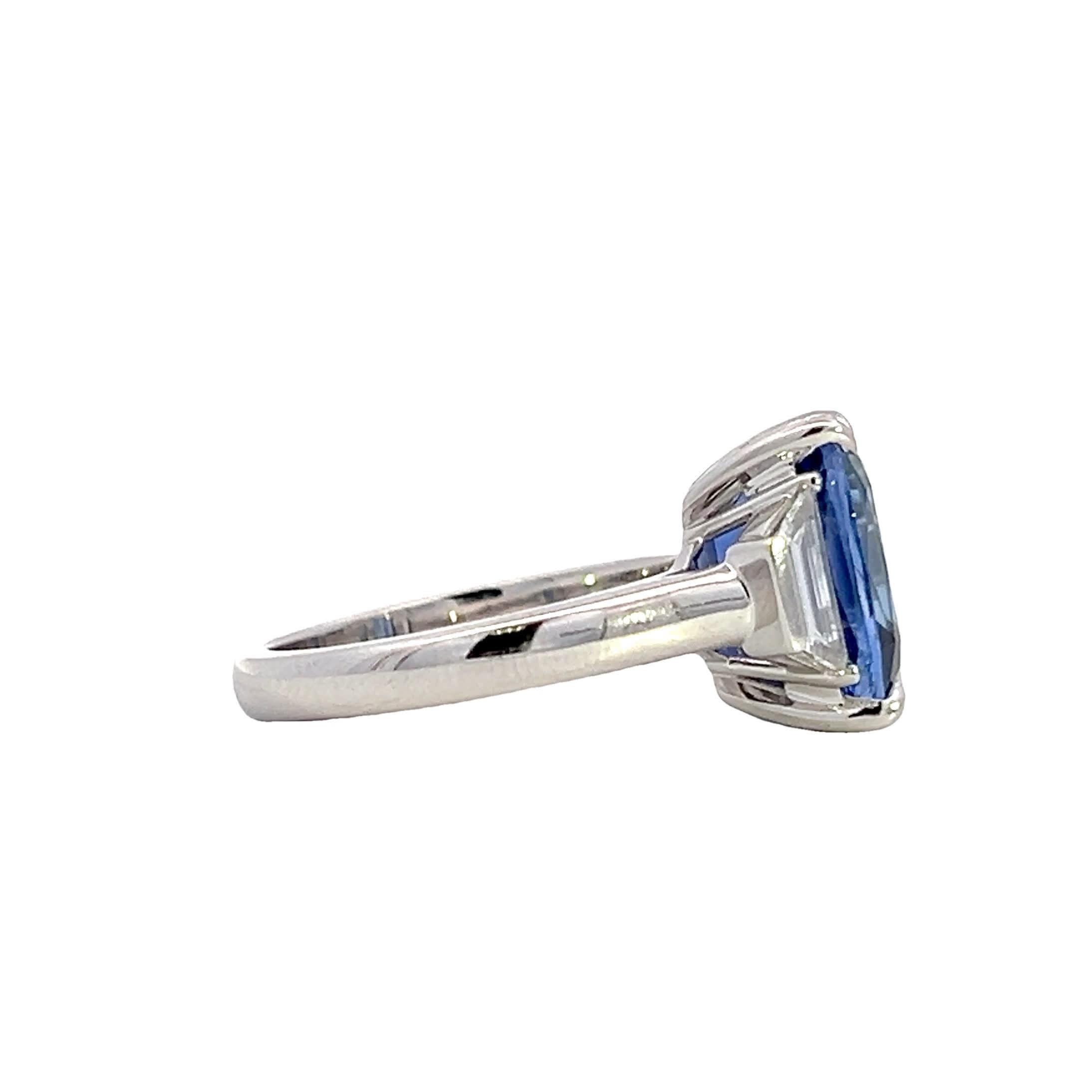 Questo splendido anello presenta un affascinante zaffiro blu intenso al centro, affiancato da due scintillanti diamanti baguette. Il design elegante e la squisita fattura ne fanno un pezzo senza tempo, perfetto per ogni occasione speciale.