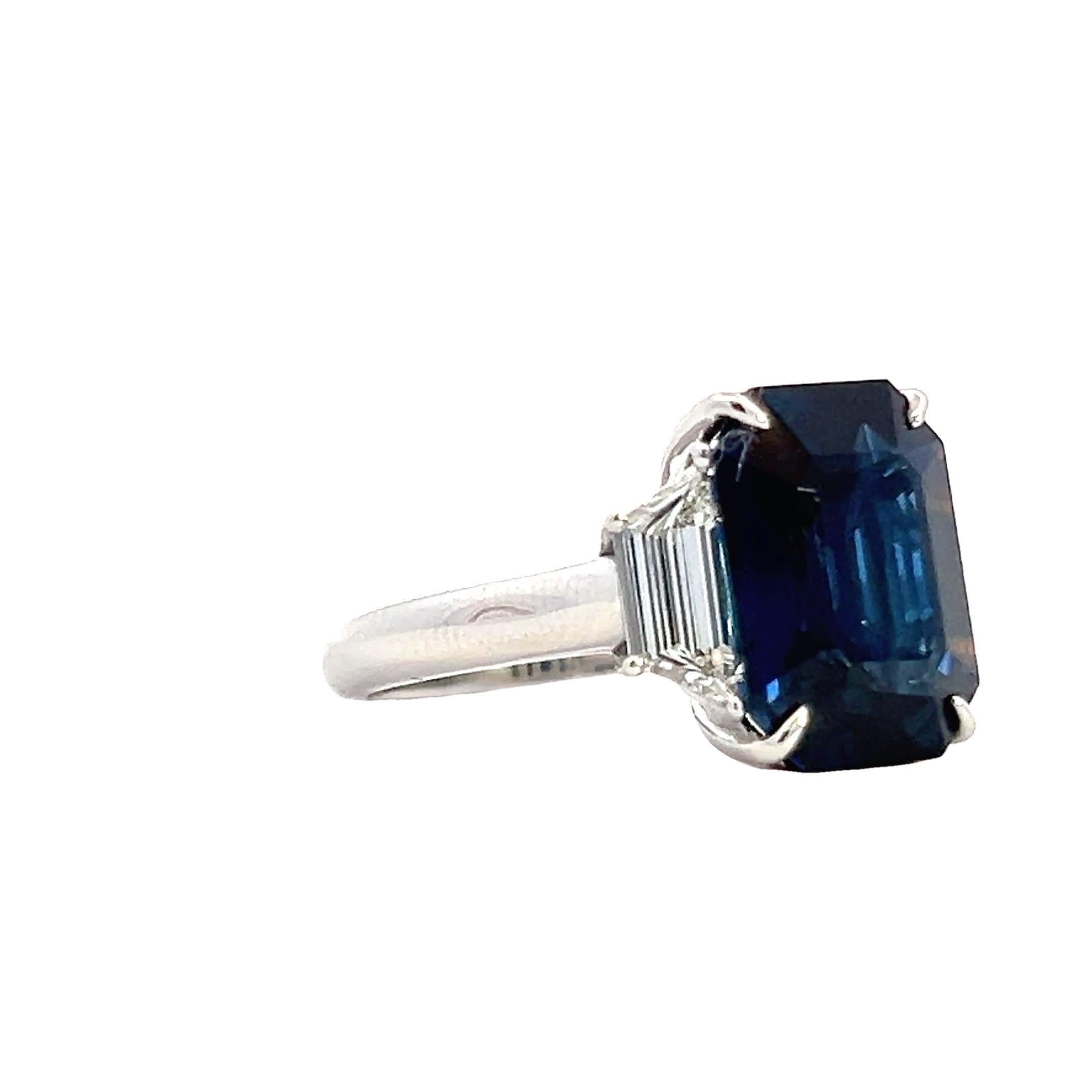 Dieser elegante Ring zeigt einen atemberaubenden tiefblauen Saphir, der sorgfältig in Smaragdform geschliffen ist. Der Saphir wird von zwei schimmernden Diamanten auf beiden Seiten flankiert und ist in ein makelloses Platinband eingefasst, das