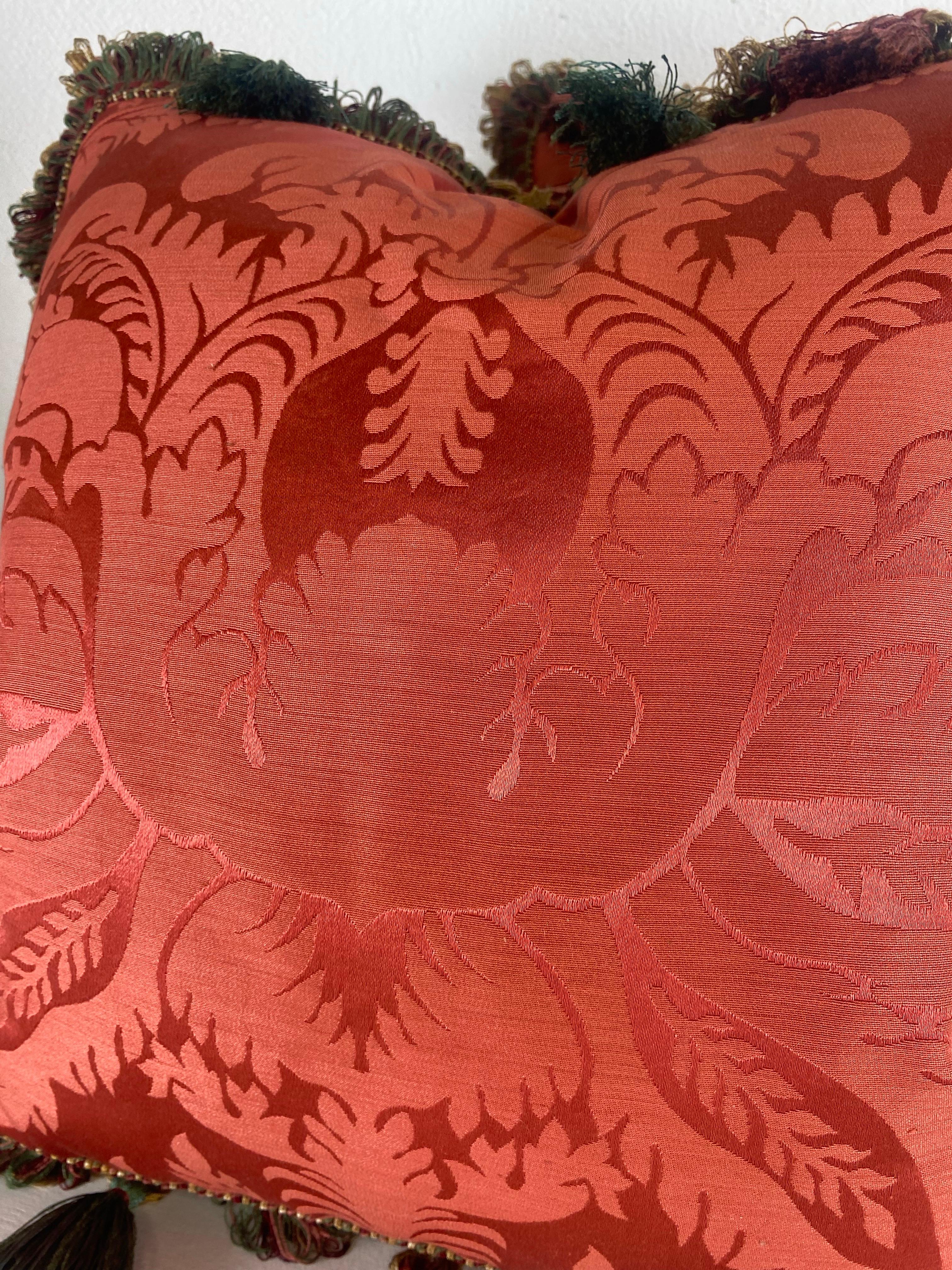 Si tratta di una coppia di eleganti cuscini con nappe in seta Scalamandré. Questo bellissimo tessuto vintage in seta color rosa intenso presenta un classico motivo damascato con una frangia di nappe complementare lungo i bordi. Il rovescio è una