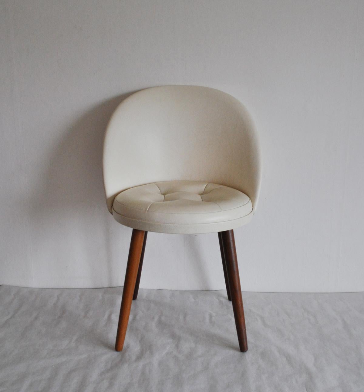 Elegant Scandinavian vanity chair designed in the 1950s.
The chair is mounted on tapering teak legs. Seat and back upholstered with artificial skin.
Measures: Seat height: 41 cm
Patinated with signs of wear consistent with age and use.