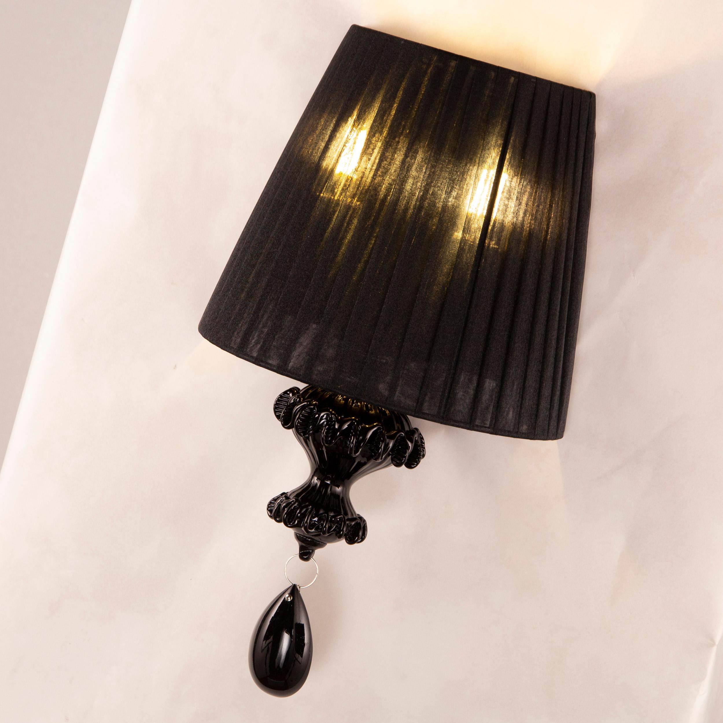 Elegant sconce 1 arm in black Murano glass with black plissé lampshade Montecristo by Multiforme

A collection that ideally recalls the splendour of the past, the sumptuous ballrooms of ancient Venice. A combination of craftsmanship skilfully
