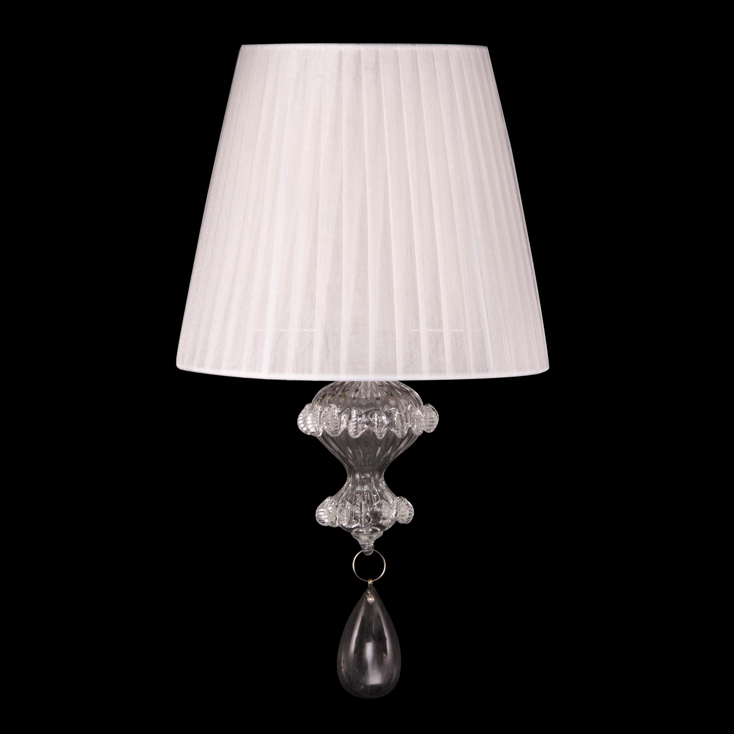 Elegant sconce 1 arm in transparent Murano glass with white plissé lampshade Montecristo by Multiforme

A collection that ideally recalls the splendour of the past, the sumptuous ballrooms of ancient Venice. A combination of craftsmanship skilfully