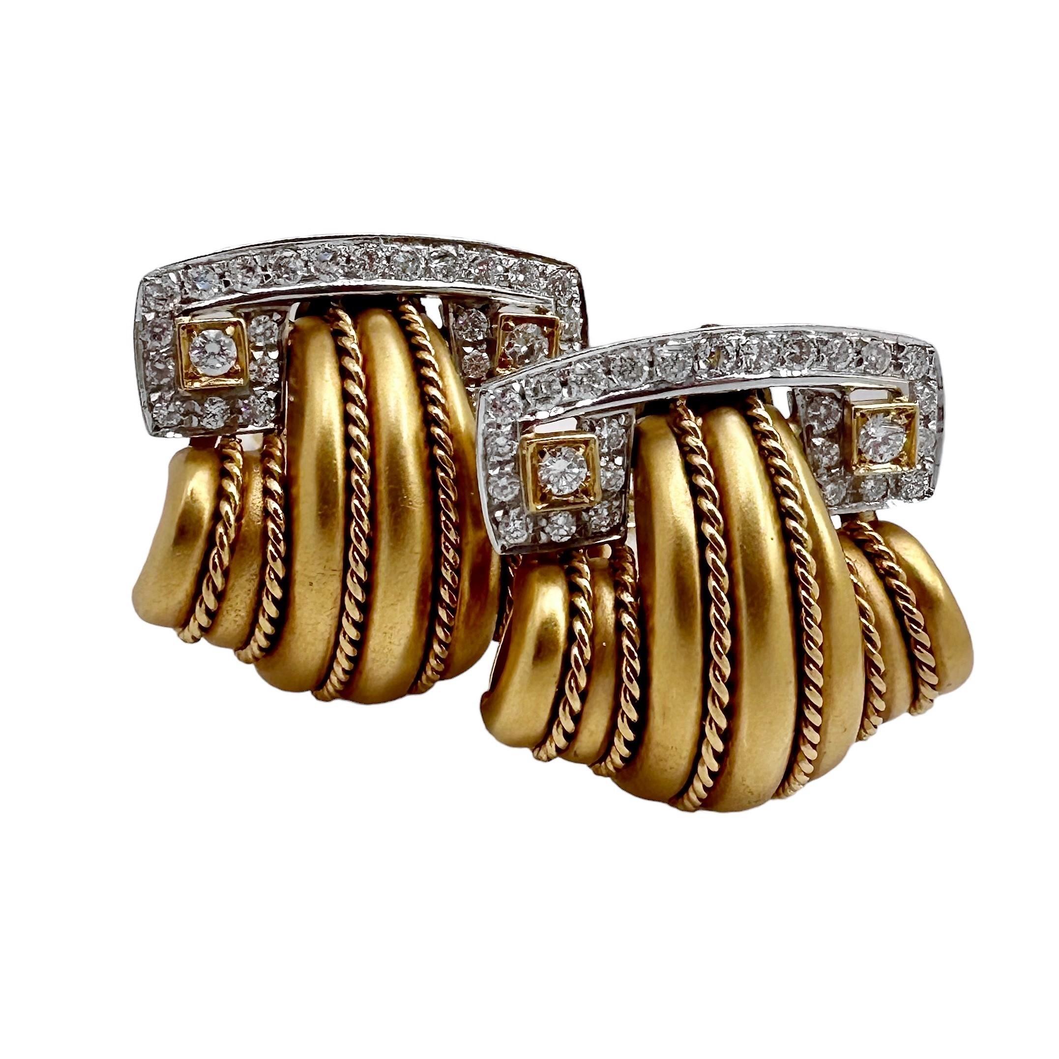 Cette paire classique de boucles d'oreilles en or jaune et blanc 18 carats du milieu du 20e siècle est non seulement élégante, mais aussi d'une facture exquise. Au total, cinquante-quatre diamants de taille brillante sont sertis dans des plaques