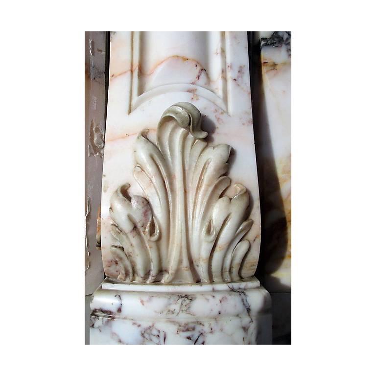 This elegant, antique Louis XV-style fireplace was made of the multicolored marble Skyros, to find on the island Skyros-Greece.
The work of sculpture is extremely well-done, modest but very fine in details. The slightly curved frieze is decorated