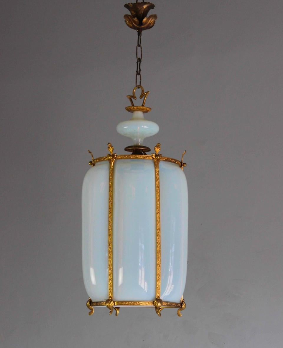 Acquistata in Europa, questa lampada presenta pannelli di vetro curvo soffiato a mano, con dettagli in ottone inciso, che ancorano questo bellissimo pendente, con un originale baldacchino a motivo floreale. Ha bisogno di essere ricablato. Il negozio