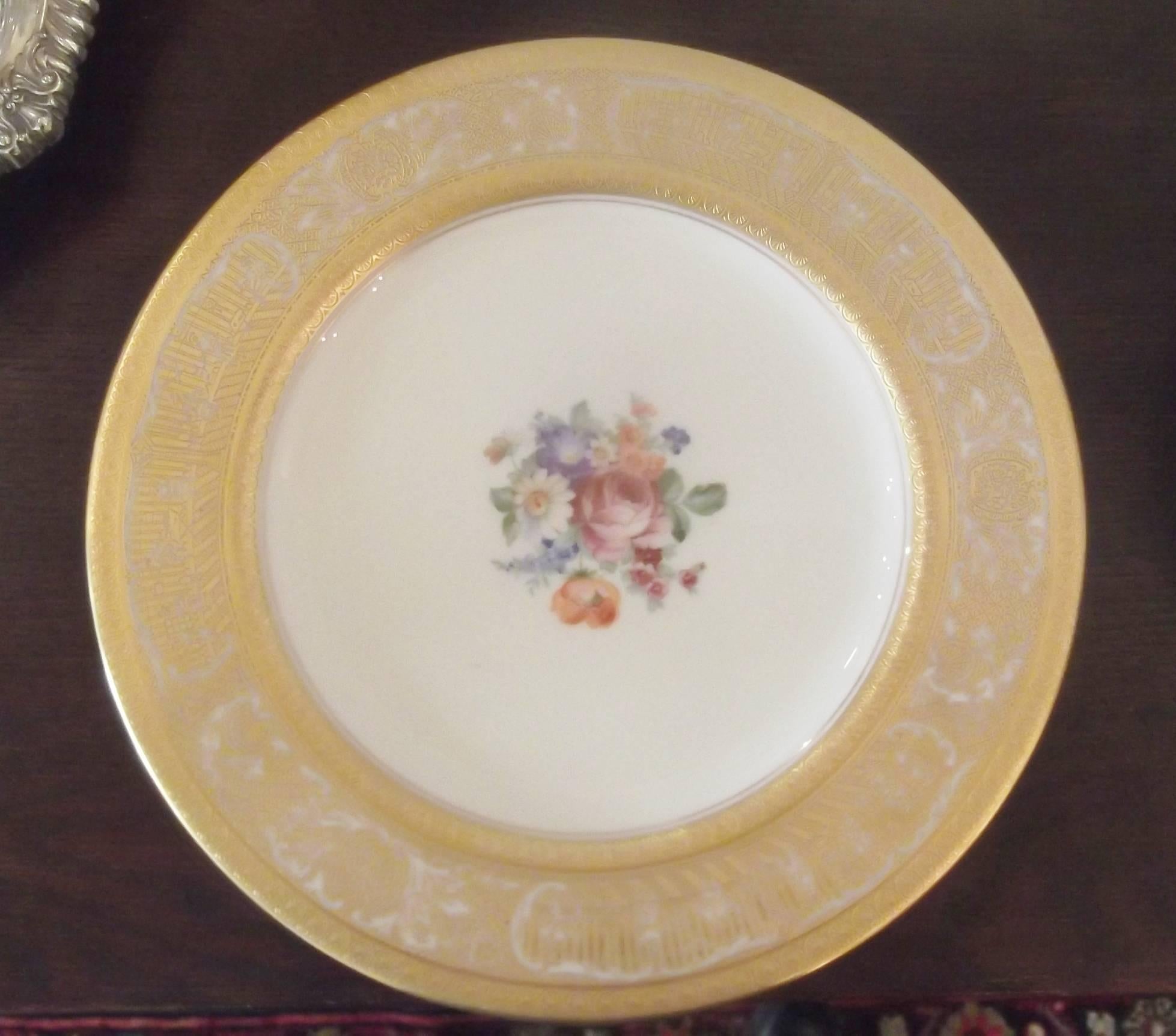 A set of 12 heavy gilt bordered service plates with floral centers.
Textured gilding around the edge with delicate floral bouquet medallions. Excellent condition and would display beautifully in a cabinet or set a luxurious dinner table.