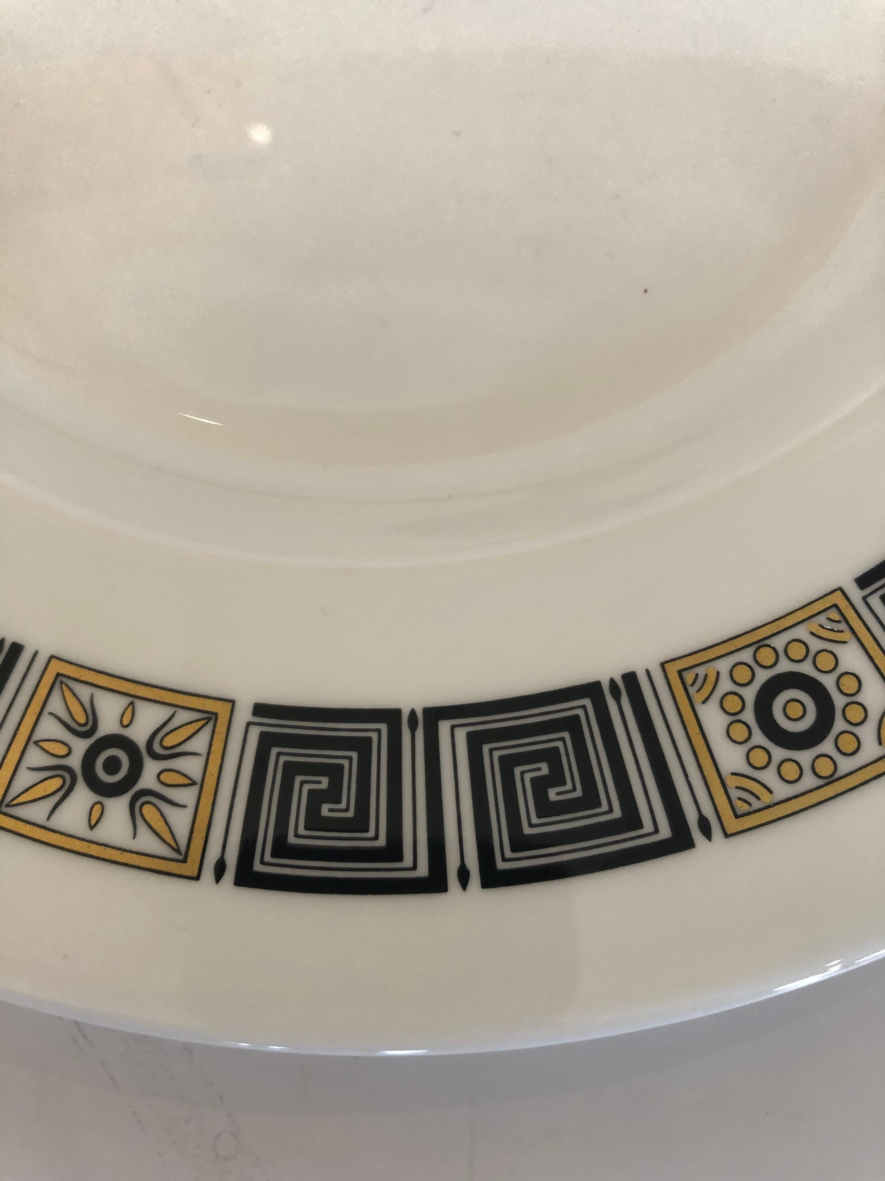 A delicious set of 12 Wedgewood dinner service plates having black and gold border with fabulous Greek key motife.