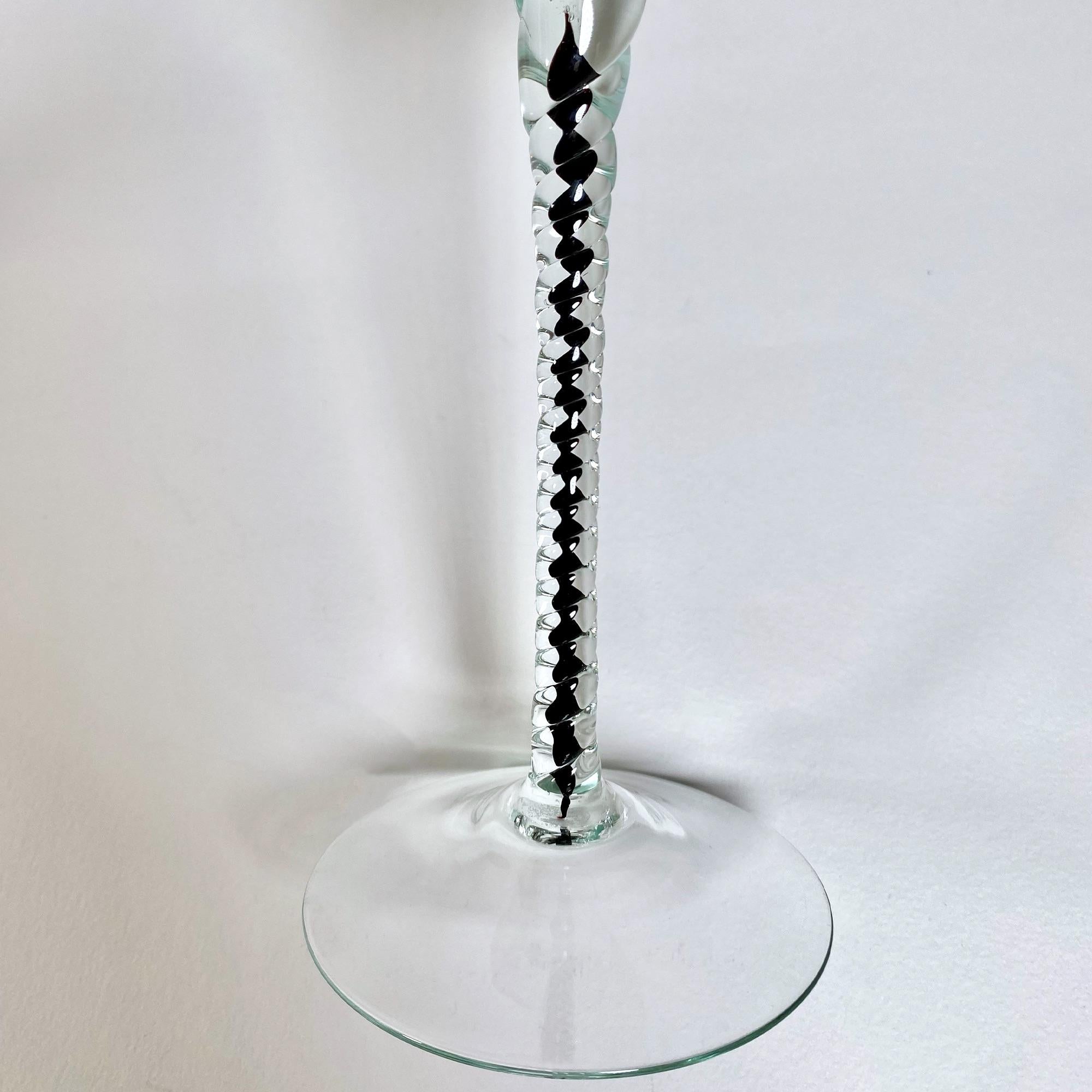 Gönnen Sie sich zeitlose Eleganz mit diesem exquisiten Set aus zwei Murano-Glas-Stielgläsern, von denen jedes die unvergleichliche Handwerkskunst der 1960er Jahre widerspiegelt. Diese atemberaubende Collection'S umfasst ein weißes Glas mit leuchtend