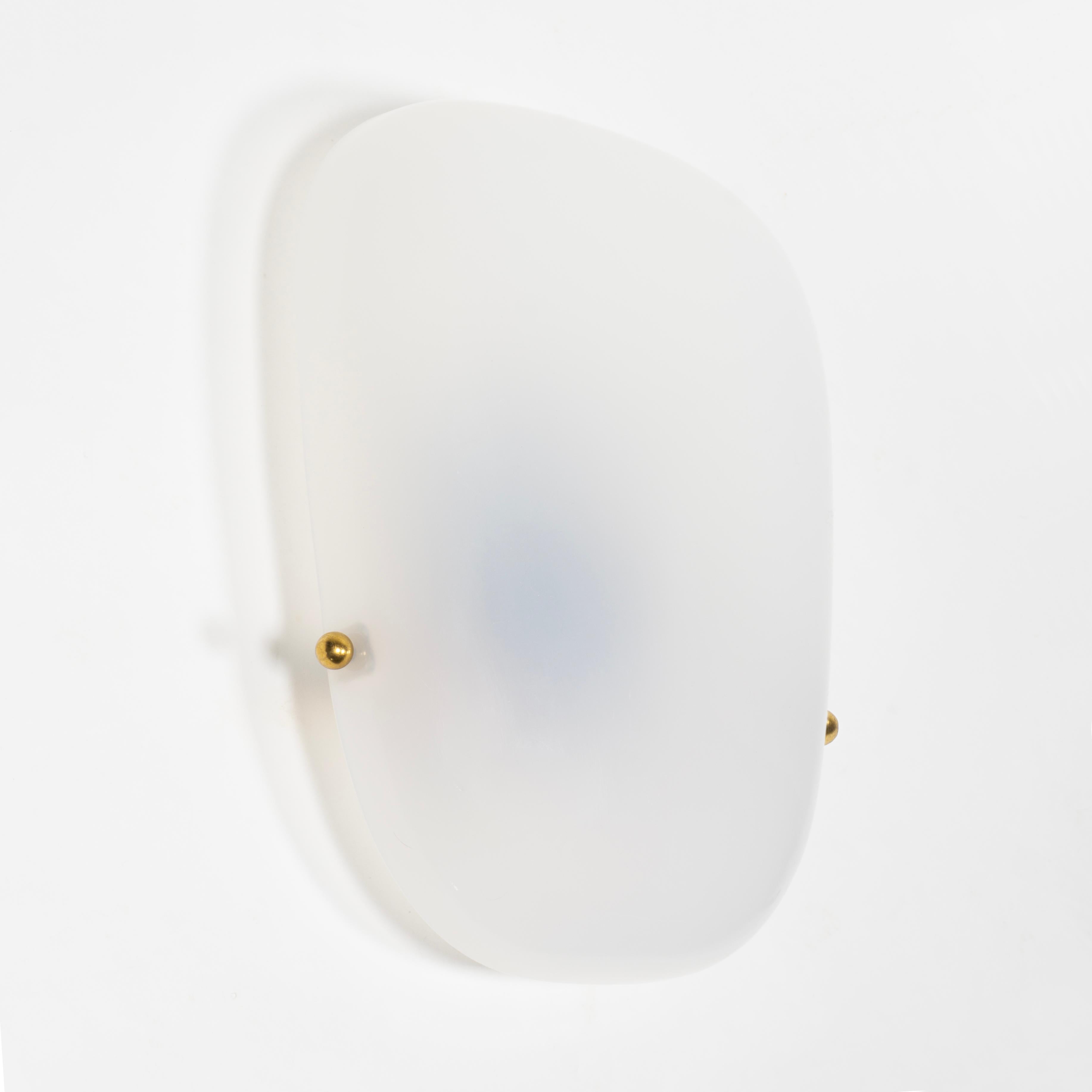 Grande, elegantissimo e intramontabile set di quattro appliques degli anni Cinquanta.  
Queste semplici ma eleganti lampade da parete sono realizzate in plexiglass bianco curvato. I paralumi sono fissati ai raccordi in ottone con due sfere in ottone