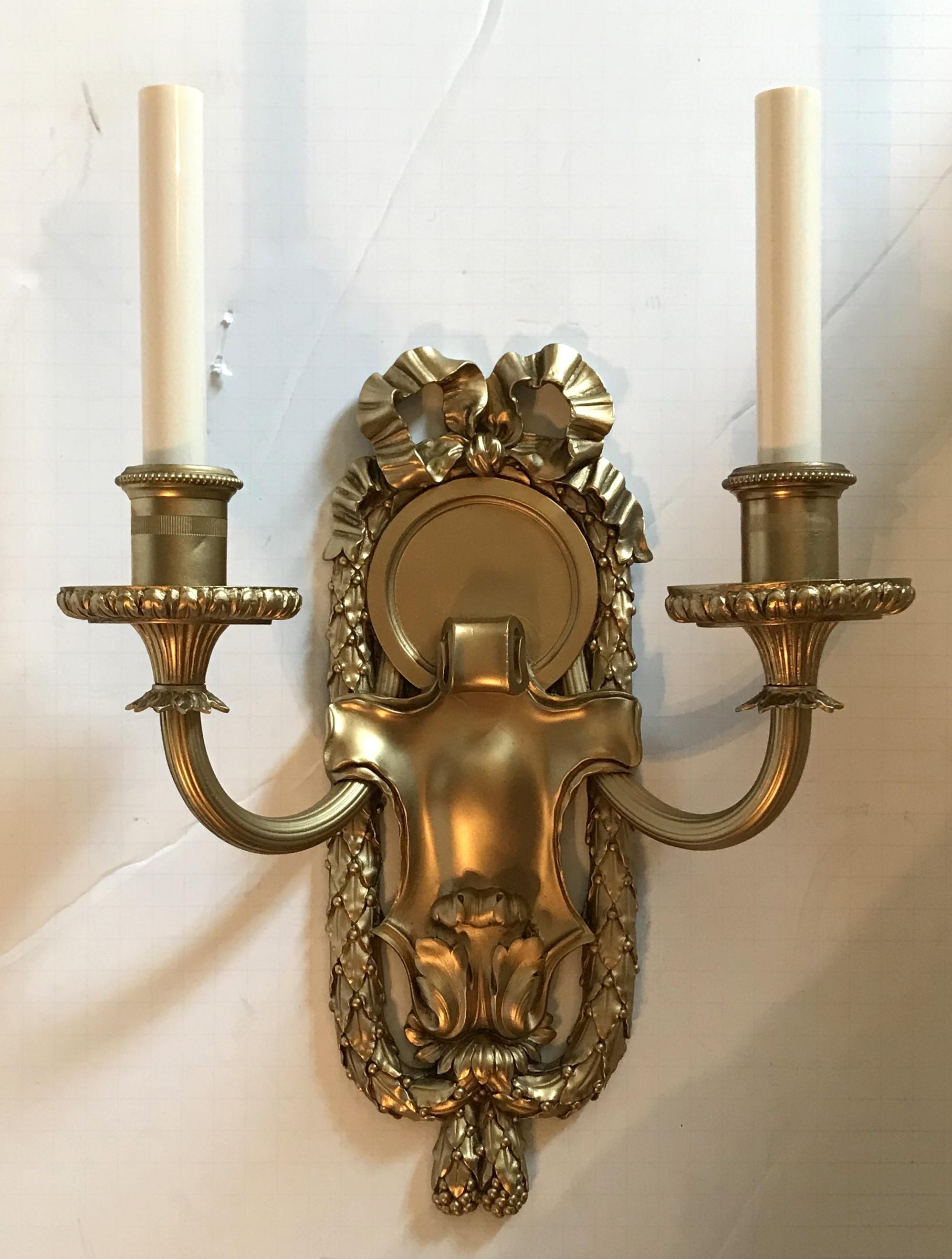 Elegant set of 5 E.F. Caldwell marked bronze sconces with embellished bow top and framed with filigree draping. With a softly aged gilt bronze patina, the sconces are set off with a wonderful center medallion, the two fluted arms, floral decorated