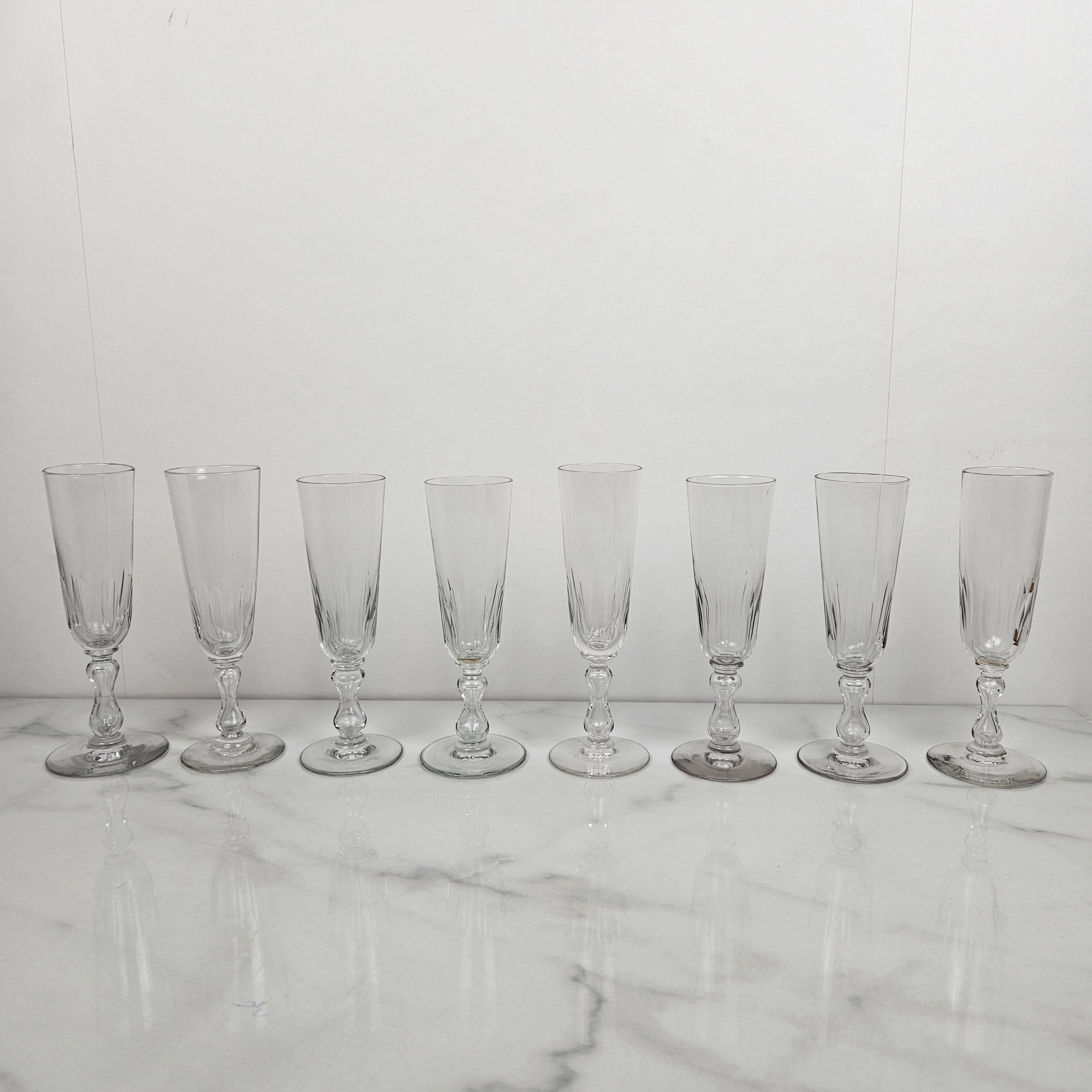 This stunning set of eight antique French champagne flutes beautifully showcases the craftsmanship of the late 19th century. 
Each flute is hand-blown from clear glass and features a finely cut bowl and stem, that includes a charming air bubble,