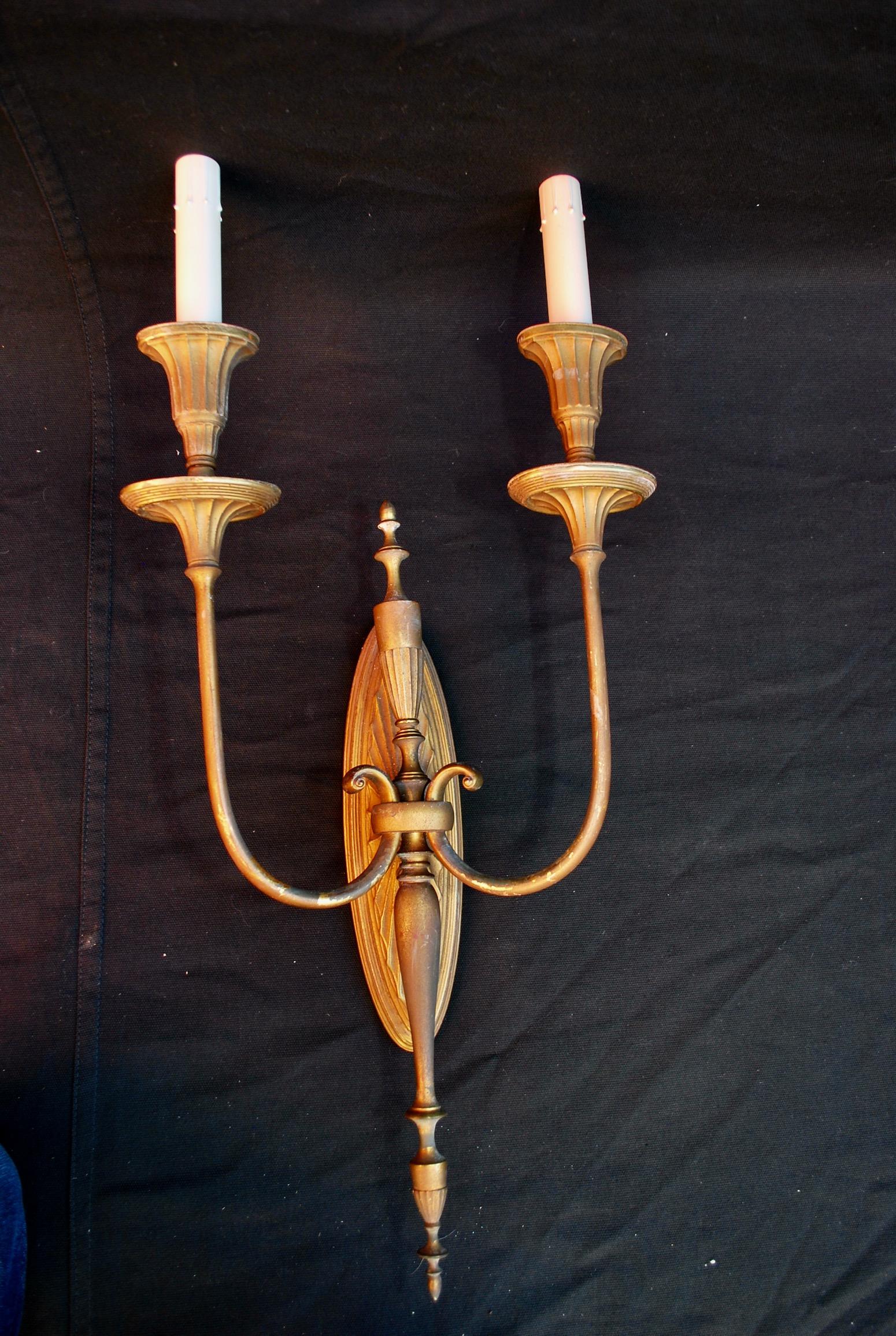 A beautiful set of three large brass sconces, we have a fourth sconce but it is missing one center finial, the patina is much nicer in person.

 