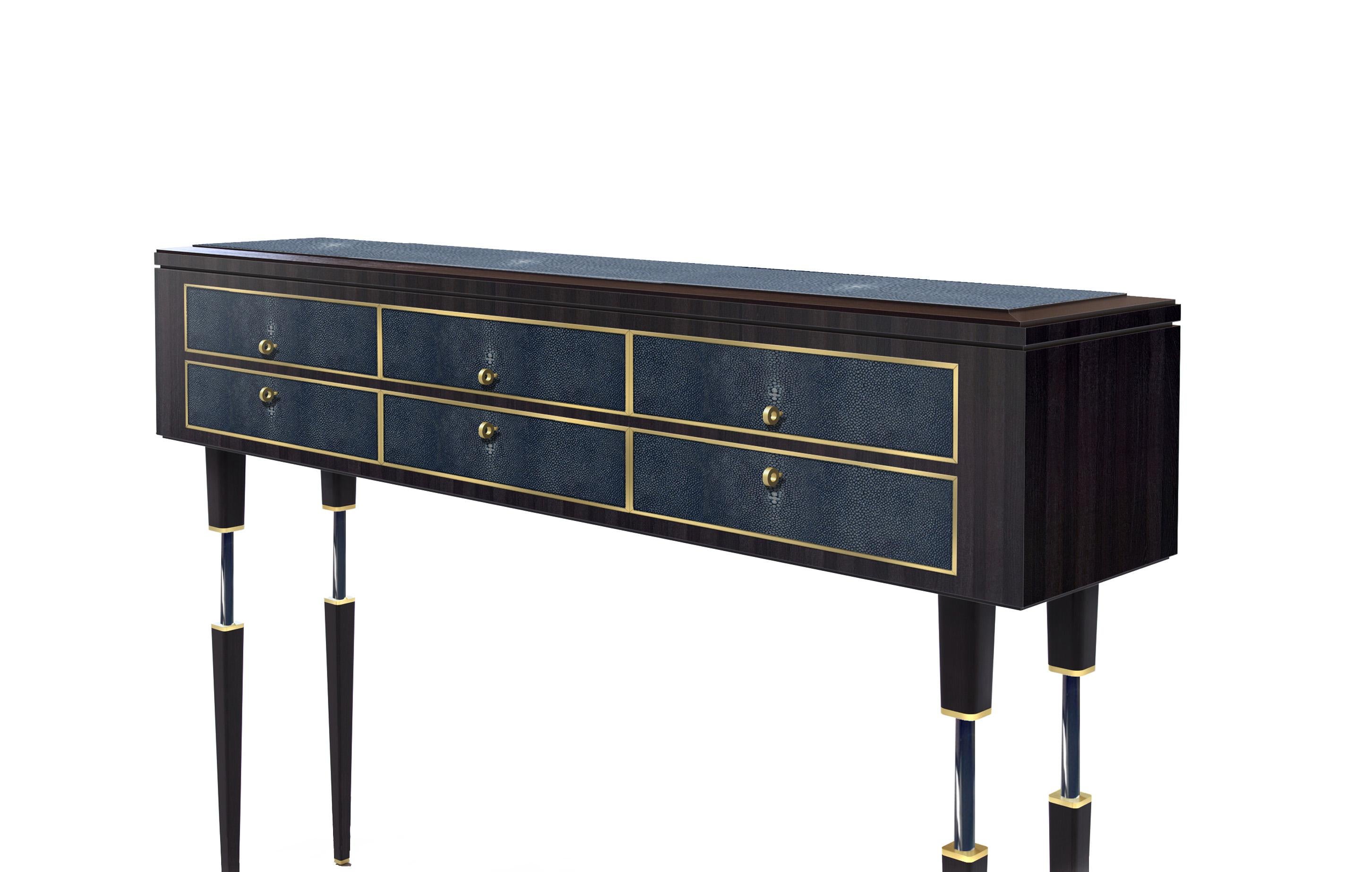 This modern console table designed in clean, simple lines and mixture of materials. The top and drawer fronts of the table are wrapped in blue Shagreen leather, highlighted with brushed brass details. The satin finish of rich and dark chocolate