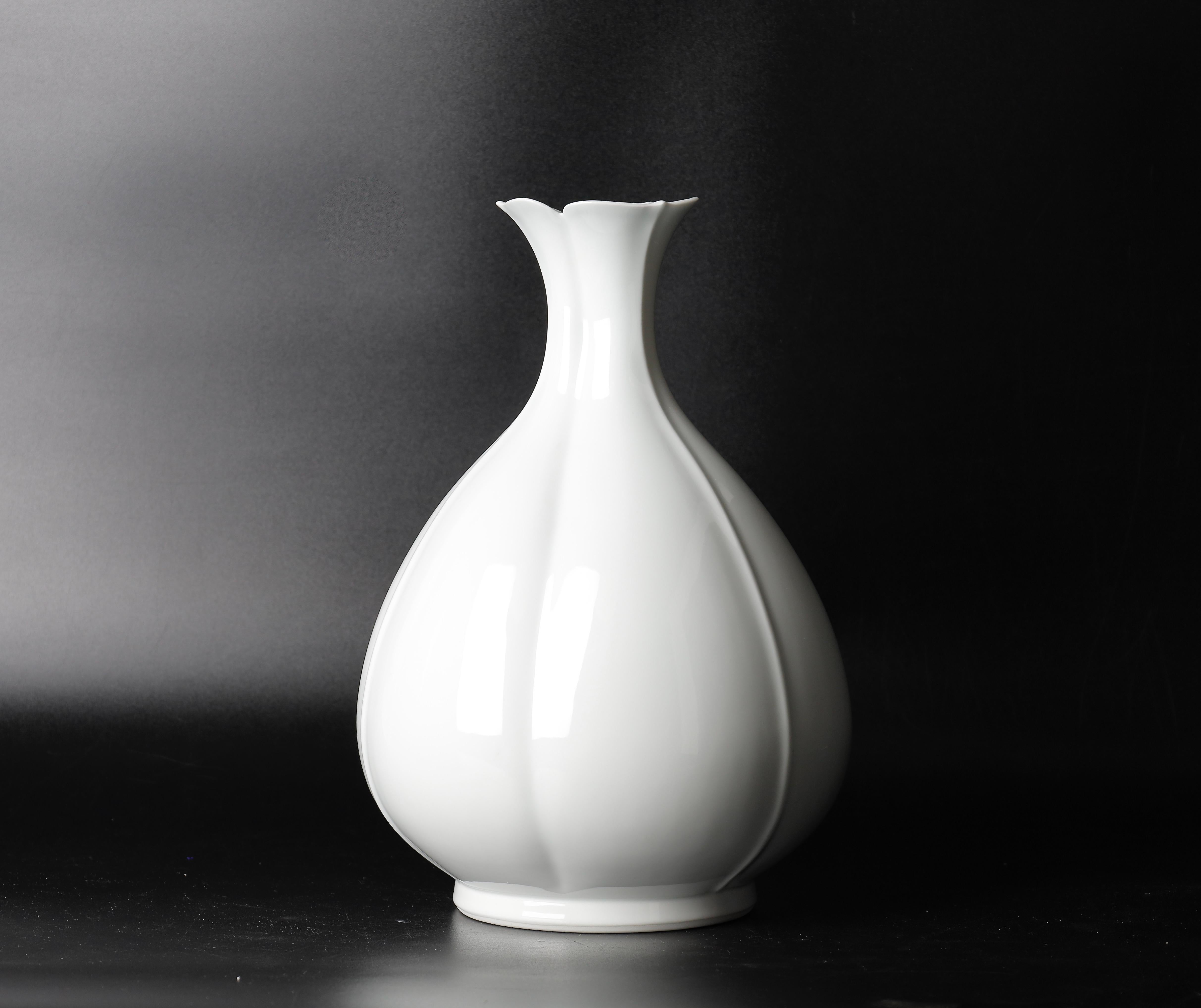 A beautiful contemporary porcelain vase by the talented Nitten artist, Nishiyama Tadashi. This elegant vase is a stunning addition to any interior design or a collector's collection. 
The vase features a flowerlike shape with a pure white color